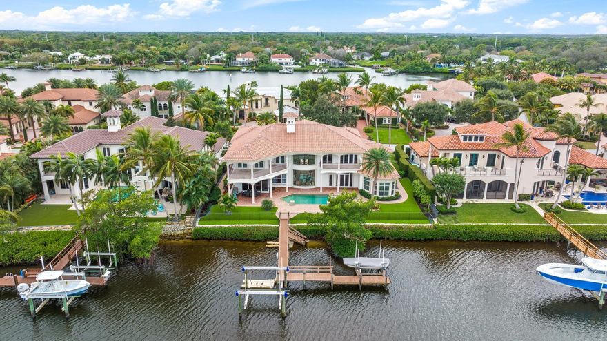 Enjoy breathtaking Easterly views of the wide water, overlooking the Loxahatchee River, from this exceptional home located on a private island in the prestigious Islands of Jupiter. Thoughtfully designed for comfort and functionality, this residence features a ground-floor primary suite, an elevator, and a large upstairs loft that can be used as a gym or an entertaining area. Recent upgrades include a brand-new 2024 roof, fresh landscaping with new trees, and newly installed synthetic turf for easy maintenance. Boating enthusiasts will love the private dock with a lift, offering quick access to the Jupiter Inlet and nearby sandbars. The spacious three-car garage provides ample storage, while the lush outdoor setting enhances the natural beauty of this property.