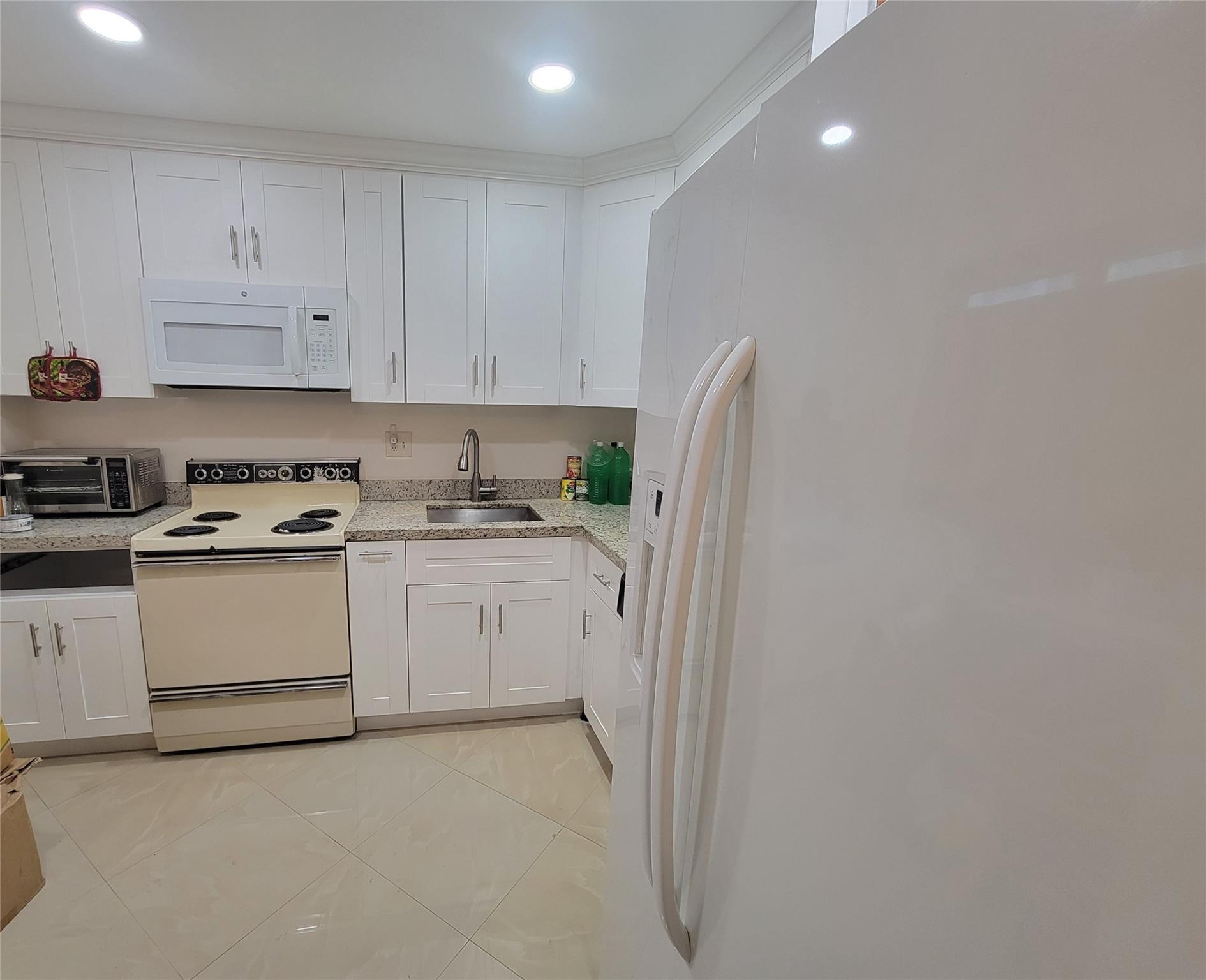Come see this beautifully remodeled 2/2 condo unit on first floor of 1090 sq. ft. The wonderfully updated white kitchen with soft close drawers, quartz counters and 20x20 polished porcelain tiles through entire unit including bathroom and screen porch. Master suite with large waking-closet, master bath comes with shower & bath. Impact windows and Impact door. Upgraded Electrical Panel. Low HOA fee $339/monthly. Lots of guest parking. 55+ community