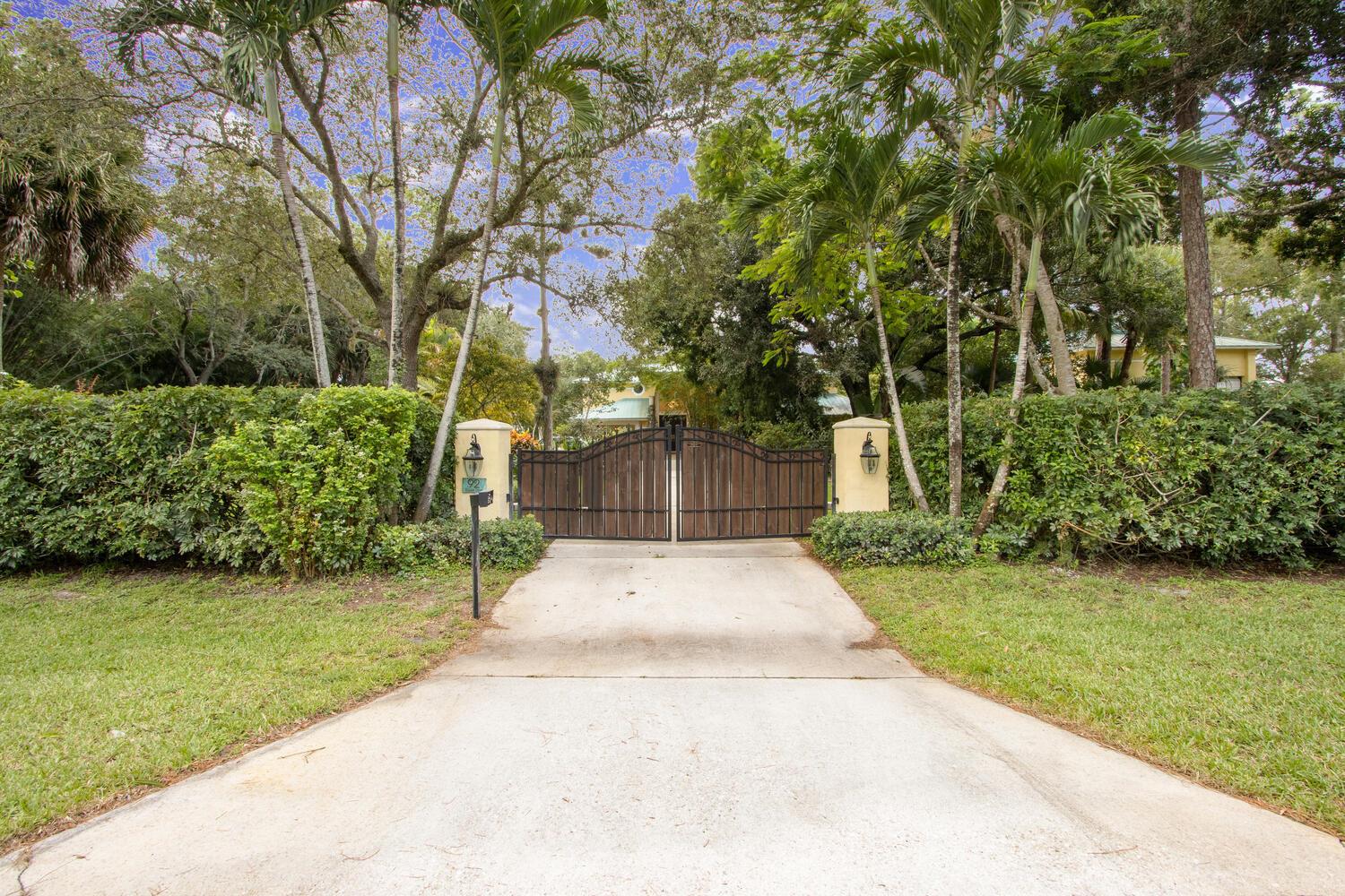 Privacy, Serenity, Security. This beautiful spacious home nestled on 1.1 acres of luscious landscape, is in the heart of Wellington. With no HOA, this spectacular private home with 5 bedrooms and 5 baths is a bike ride away from A+ rated elementary, middle, and high schools. The property is completely fenced with two gated entrances. The Chef's kitchen overlooks a pool with a waterfall resembling a tropical paradise. 4 of the 5 bedrooms have private bathrooms including a second master suite on the ground floor which provides a separate living space. Additional features include Reverse Osmosis water system and hurricane impact windows. For car, RV and boat lovers, a 32X48 detached garage with 22' ceiling built in 2019 with a 768 Sqft upstairs office. Garage can house 5 cars and/or 40' RV.