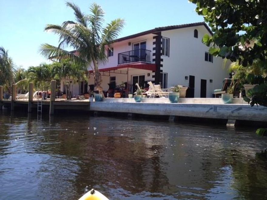 Spacious 2 story home w/100+ feet of waterfront. Heated pool sits privately off to the side w/tremendous water views. A 60 ft covered veranda gives you outside & inside living areas w/water views. 4 brs have water views! Open kitch,granite counters & SS appl. Outdoor dining area awaits your next cocktail party. Tumbled marble flrs, HURRICANE IMPACT WINDOWS & DOORS T/O. Dbl garage. You have every modern convenience, yet a charming & artistic décor. Could separate master suite w/kitch & l/r from main area.