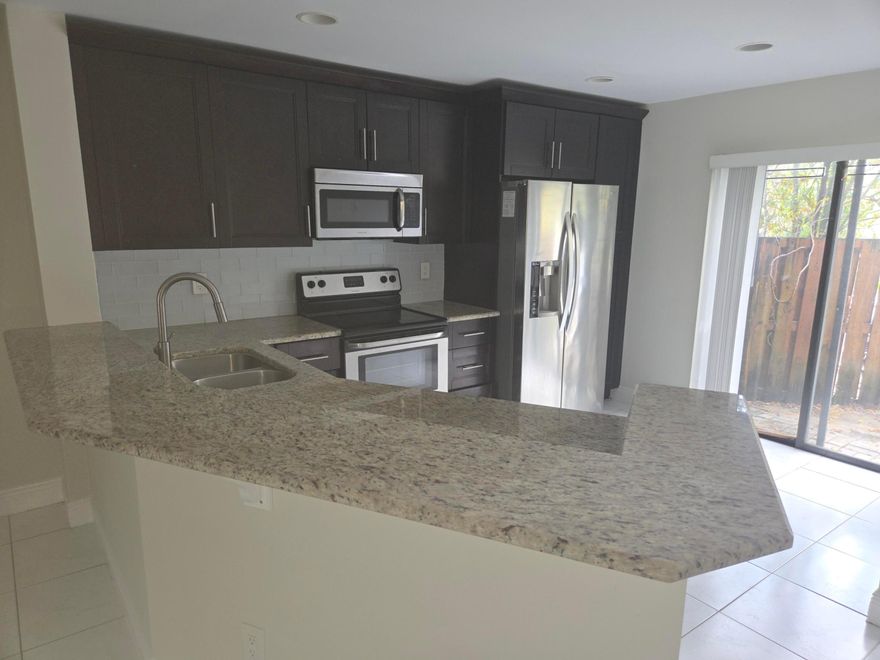 This cozy three-bedroom townhouse sits in a quiet neighborhood with easy access to shops and parks.3mn walk to place of worship, Tiles floors throughout, a modern kitchen with granite counters,  Three spacious bedrooms upstairs, each with plenty of closet space. There's a main bath and an en-suite in the master. The living area flows into a dining nook, perfect for hosting. Out back, a small patio for morning coffee or BBQs. Two-car spots, in-unit laundry, and central AC/heat