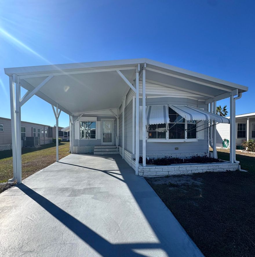 Lovely 2-bedroom 2-bath home in the desirable 55+Spanish Lakes Country Club Village community. The home has lovely coastal decor. New appliances and new cabinets in the kitchen. The roof is metal. This home has no carpet; laminate flooring runs throughout. New carport, front door, Interior of the home has been painted, New ceiling fans. Newer washer and dryer.  The home is being sold partially furnished. This home sits close to the park entrance and the community center. Lawn care, trash removal, and golf are included in the lot rent. The community includes 2 pools, tennis, pickleball, bocce ball, and shuffleboard. clubhouse and much more. Must See!