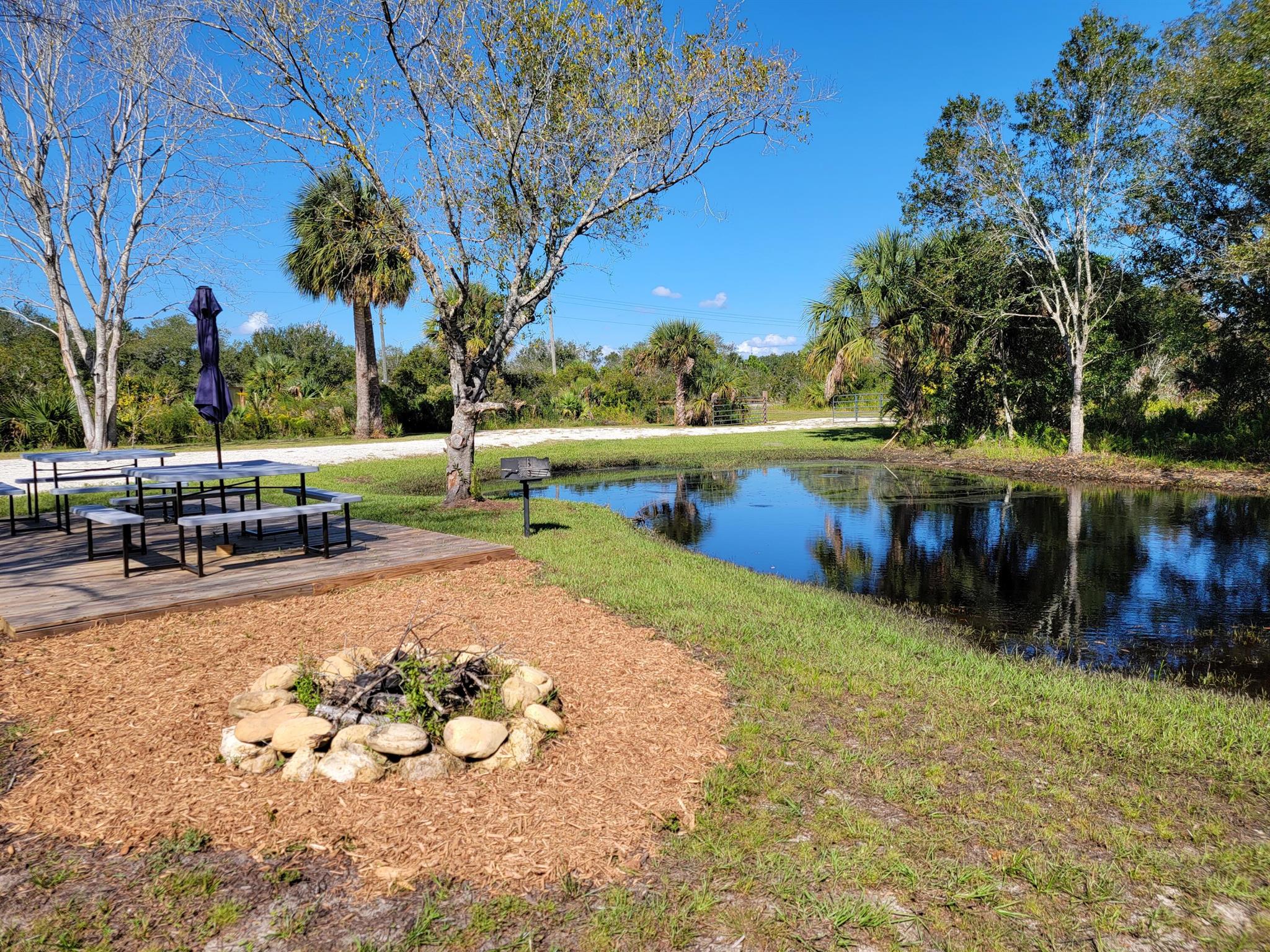 Gorgeous, well-located on paved road, and park-like landscaping! Your own private paradise. No driving down long bumpy dirty roads that get sloppy when it rains. We have installed a double wide culvert and locking gate. The property has a pond, extra parking area, natural canal to the rear with a bridge over it that connects to a nature trail on property, shooting range berm, 12 X 22' deck that has two 8-person lifetime picnic tables on it, park grill, natural stone firepit, horseshoe pits and more. This is one of the nicest and most beautiful properties in the Viking Prairie area. The entrance to the State Park is just a little over two miles north. Left as natural as possible for privacy. Large sodded areas for plenty of tent/RV room.