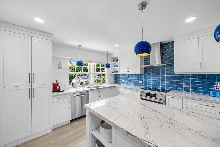 A rare offering in the heart of Delray Beach, this fully gut-renovated 2-bedroom, 2-bath residence blends European sophistication with effortless coastal living. Never occupied since completion, the home is completely move-in ready and positioned just one block from the Atlantic Ocean and three blocks from Atlantic Avenue's renowned dining, shopping, and nightlife.  Located within an intimate six-unit building, this property offers privacy, low HOA fees, and the charm of a boutique residence rather than a large condominium complex. Included are two dedicated parking spaces—an exceptional convenience in this coveted beachside neighborhood.  Inside, every detail has been reimagined. The unit was taken down to the walls and rebuilt with all-new plumbing, electrical, finishes, and impact glass The former enclosed layout has been transformed into a bright open-concept living space centered around a designer chef's kitchen featuring Bosch stainless steel appliances, RO water filter, two refrigerator drawers individually temperature programmable,custome cabinetry, artisan navy tile backsplash, oversized quartzite island, pendant lighting, and wide-plank porcelain flooring throughout.  The primary suite is a private retreat with blackout shades, custom drapery, a walk-in closet, and a spa-inspired en-suite bath featuring European Duravit fixtures, floating vanity, LED medicine cabinet, frameless shower, and striking porcelain tile.  The second bedroom offers exceptional flexibility with its own full bath and a permitted concealed LG washer/dryer, making it ideal for guests, office use, or seasonal living.  A unique standout feature is the expansive 240sf patio—an outdoor living room large enough for dining, lounging, and daily enjoyment, surrounded by lush landscaping for privacy. Morning coffee, evening cocktails, and seamless indoor-outdoor living await.  This is a rare chance to own a turnkey beach retreat with designer finishes, modern systems, private outdoor space, and an unbeatable Delray Beach location.