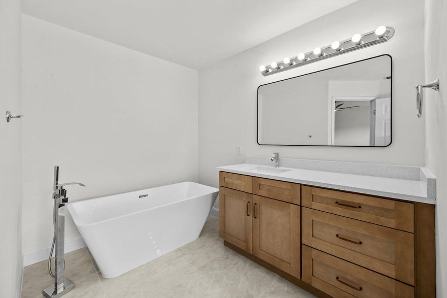 Showings must be scheduled with Showingtime. Exquisite 3-bedroom, 2-bathroom residence, fully renovated in 2026. The gourmet kitchen boasts luminous Calacatta quartz countertops, bespoke soft-close shaker cabinetry, and premium high-end finishes, designed to inspire culinary excellence. Luxurious spa-inspired bathrooms feature sophisticated tile work, free standing tub, gorgeous vanities, and contemporary fixtures, elevating daily rituals to a serene escape. Impeccable waterproof laminate flooring, freshly painted interiors and exteriors, and brand-new, top-tier appliances blend style with functionality. Enjoy effortless access to I-95, premier shopping, and dining, with the freedom of no HOA restrictions. This residence seamlessly blends modern luxury with timeless comfort.