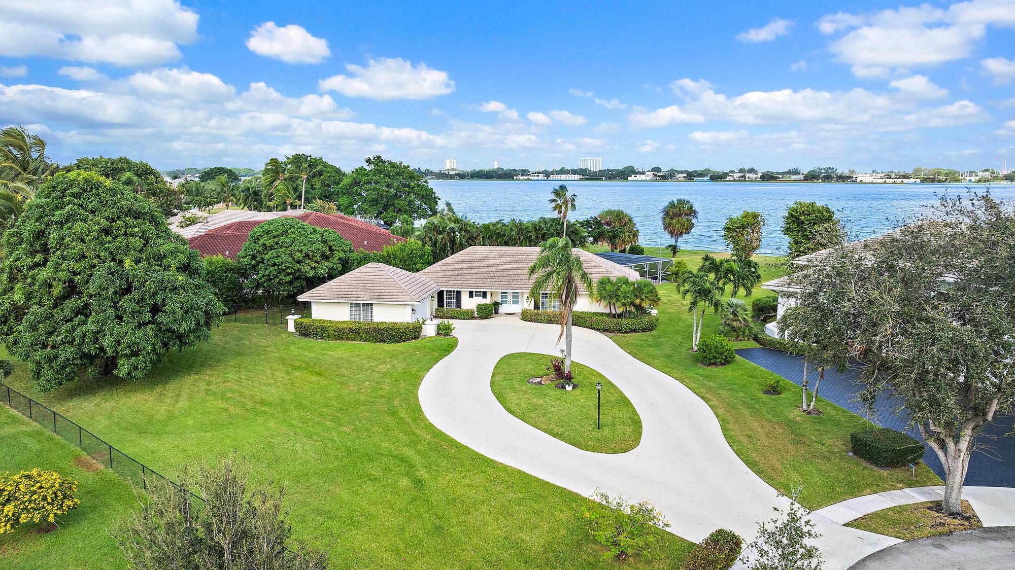 Largest Lot of Land Real Estate on a quiet cul de sac overlooking Lake Mangonia. The lake is protected as a water source, light boating and sailing is allowed. This community is very desired for its prime location close to all points of interest. West Palm Beach has become the place to live and to enjoy the Florida Palm Beach Life Style adjacent to Belgrove Marriott Autograph Hotel & Dutchman's Pipe Golf Club. The location is only minutes from beaches, PBI airport, Palm Beach Island with its top dining and shopping and WPB cultural happenings with Kravis Ctr and Norton Museum, convention Ctr ++. The home has been totally renovated and features an open concept living area with lots of windows allowing gorgeous views on the lake and the pool area. Split bedrooms with bathrooms. Come to see.