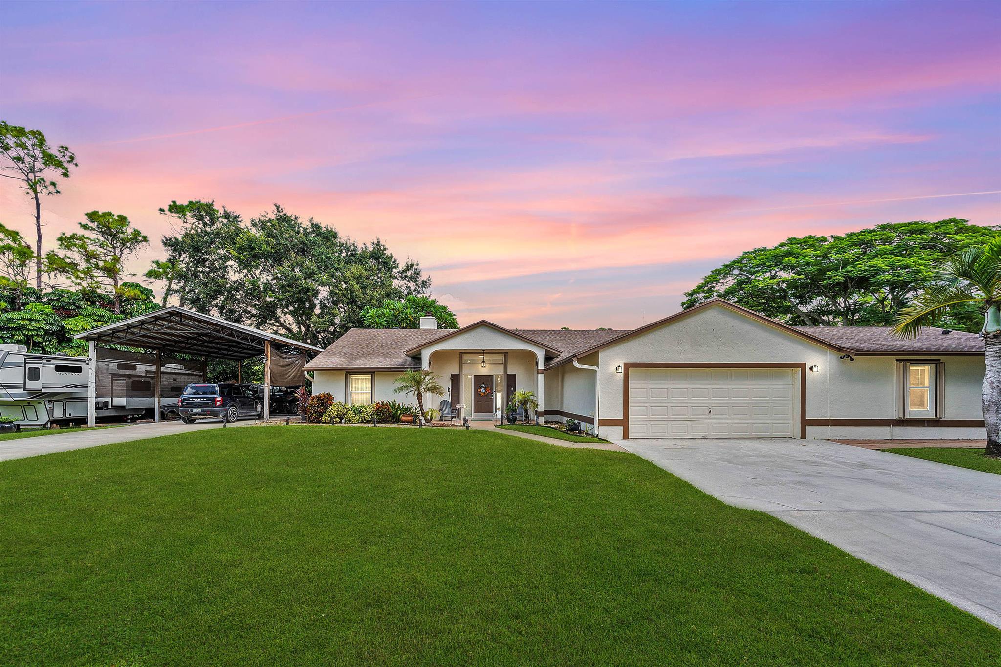 WOW FACTOR ALERT! This is a stunning nearly 1.5 acres.retreat of pure Florida paradise. NO HOA, NEW ROOF & RARE DUAL DRIVEWAYS! The main home offers 3 beds / 2 baths, an airy open layout with vaulted ceilings, and a beautifully UPDATED kitchen with granite counters, subway tile, and rich cabinetry. The primary suite impresses with a custom walk-in closet and spa-like CABANA bath. A remodeled IN-LAW SUITE with its own entrance, full kitchen, and bath makes the perfect guest haven or rental! Outside, enjoy your private oasis POOL & HOT TUB with an OUTDOOR SHOWER, covered/screened patio, + a fully fenced yard with canal access on 2 sides. Extra perks: oversized carport with water/electric (boat/RV ready), functioning fireplace, accordion shutters, and generator hookup. Minutes to everything!