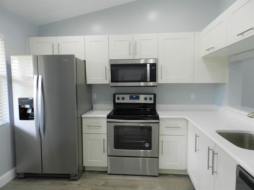 All ages welcome!  This unit has a beautiful view and totally remodeled.  White Shaker Cabinetry, Stainless appliances and quartz counter tops.  Bathrooms are superb with new vanities and tile.  Entire unit has been freshly painted and new flooring throughout.  Washer and Dryer in unit.  A/C replaced in 2019. Screened balcony overlooks golf course.  Community offers clubhouse, pool and golf.  Quiet, well-kept community close to turnpike, Wellington Green and restaurants.