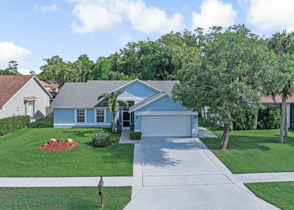 Welcome Home to this 3/2 single family home in west Lake Worth! This home is sure to catch your eye as you walk in to a large family room with vaulted ceilings giving a spacious feel. The kitchen boasts granite counter tops with custom cabinets galore, as well as plantation shutters! There's also a matching island with an overhang to create eat-in kitchen seating and a separate movable double garbage box. The luxury vinyl throughout the main living area makes it flow nicely. A huge upgrade of hurricane windows, french doors, front door, and garage door has also already been done! The backyard is fully fenced and backs up to a preserve for full privacy to enjoy the back patio at any time of day! This home has the original owner and pride in home ownership is evident! Come see for yourself!