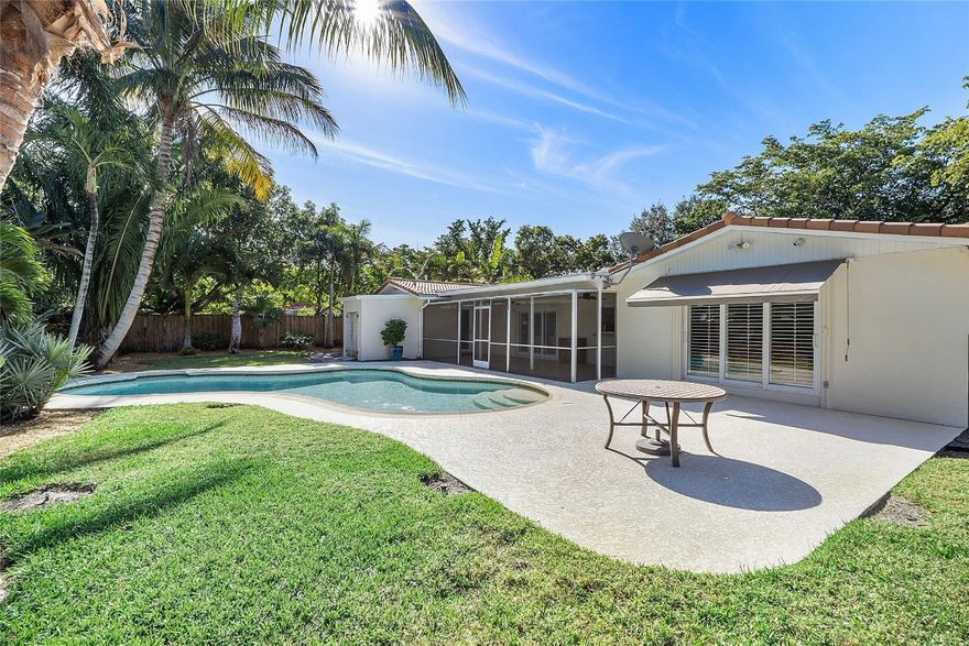 Popular,  Royal Palm Estates! This entertainer's large 3 bedroom 2 bathroom dream home features double living spaces, a tropical backyard with a pool, exterior lighting, a cabana bathroom, and lush palms from around the world. Relax in the screened-in porch with tile flooring and fans, enjoy the separate side yard for pets, and admire the custom wood fence enclosing the yard. Inside, you'll find crown molding, porcelain tile throughout, a walk-in closet in the owner’s suite, New Electrical Panel inside and outside and more. Impeccably maintained and designed for comfort and style, this home is a must-see!