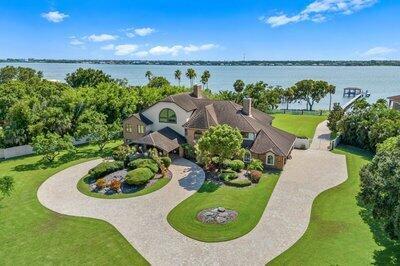 This 6BR, 5.5BA riverfront estate is a private retreat on 2+ acres with 150 feet of shoreline and over 6,600 sq ft of living space. Designed for entertaining and multigenerational living, it features a boat ramp, 300-ft dock with double slips, 10K-lb lift, and direct Indian River access. Enjoy a heated pool, spa, outdoor kitchen, and serene backyard oasis. Inside: chef's kitchen, fireplaces, wet bar, and luxe primary suite with riverfront balcony. Metal roof, impact windows, generator, 4-car garage, and more--just minutes from beaches, airport, and Space Coast industries.