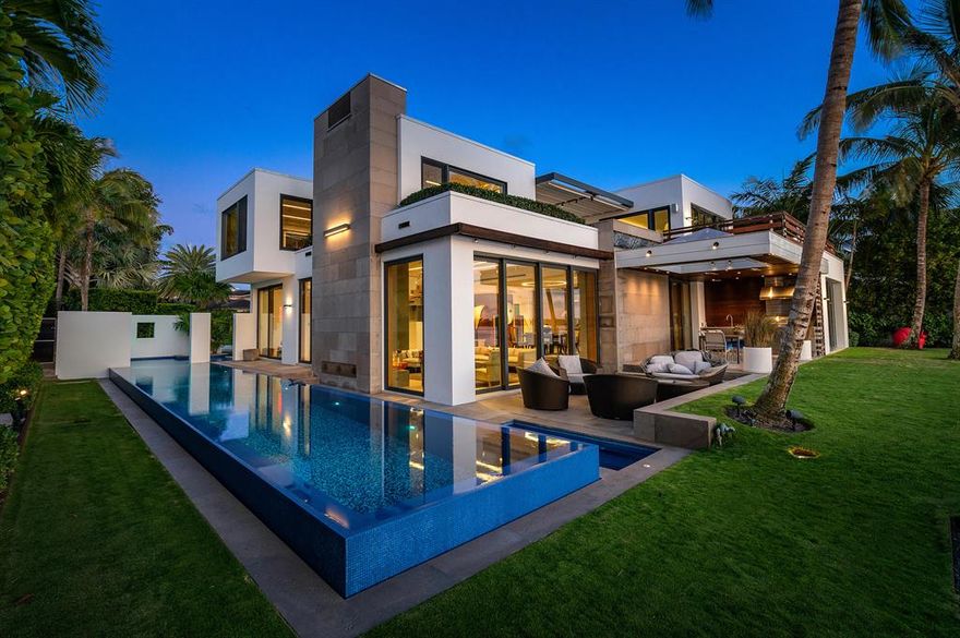 Expansive Intracoastal views from every room of this stunning 2-story Ultra-Modern Smart Home designed in 2015 by Vail architect Kyle Webb. Imagined with the purpose of enjoying indoor/outdoor living and constructed from the finest materials and finishes including wood, steel, concrete and glass to create a modern architectural symphony. Secluded behind lush landscaping and electric gates stands this elegant home featuring a front water pool streaming into the 70 foot long lap pool. The large front doors welcome you into the spacious great room facing the Intracoastal with floor to ceiling glass doors leading to a spacious deck. There you will find a complete summer kitchen, a large flat screen TV, an entertaining area, as well as the yard and the Intracoastal Waterway. The great room offers a gas fireplace, while the kitchen, designed by Bulthaup, incorporates the elements of a master chef's kitchen with a gas stove and ample counter space, plentiful storage with an area dedicated for wine, high tech lighting, and audio systems throughout. Downstairs are three bedrooms with ensuite baths, each opening onto a deck with outdoor showers and surrounded by beautiful tropical landscaping. The 2nd floor includes the main bedroom area and two offices, plus a gym reached by either an elevator or the sleek staircase of glass, steel and wood. The main bedroom doors open onto an outdoor deck, perfect for watching boats glide along the Intracoastal Waterway and enjoying the stunning sunsets. The spa-like marble master bath features indoor/outdoor bathing. This unique home combines pure luxury and sheer simplicity in a livable modern masterpiece. Ibis Isle has nighttime security and is situated across A1A from Phipps Ocean Park, the Palm Beach Tennis Center, and is very close to the Palm Beach Par 3 Golf Course. Just a short drive to Worth Avenue, fine dining and cultural centers.