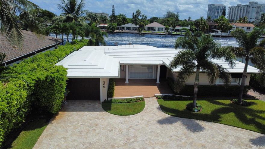 Discover the epitome of luxury living in this breathtaking Intracoastal home. Check off all your housing desires: 3 bed, 2 bath, 1 car garage, bonus den/office, pool and waterfront! This exquisite property offers the perfect blend of comfort, style and outdoor living with stunning water views. Enjoy 75 feet of waterfront with a private dock and a 25,000 lb boat lift. A sparkling pool with a heater and a large covered area provide the ultimate setting for entertaining and relaxing. The home boasts a massive paved driveway with plenty of space to park multiple vehicles or your  boat trailer or RV. Property is located 3 miles to the Hillsboro Inlet giving easy access to the Atlantic Ocean with no fixed bridges. Dining, entertainment and beach close b