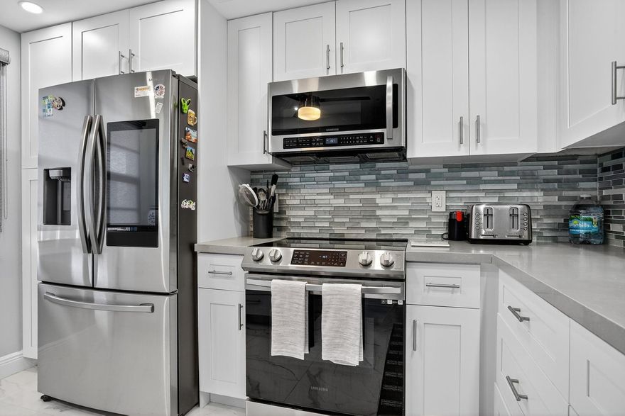 THIS IS IT — WYNMOOR'S MOST BREATHTAKING VIEW of the golf course, lake, and clubhouse! This fully remodeled 2BR/2BA condo stuns with sleek porcelain flooring, a gorgeous designer kitchen with quartz waterfall countertops and breakfast bar, shaker cabinetry, and top-tier stainless steel appliances. Both bathrooms have been tastefully updated, and there's a washer/dryer right in the unit. Impact windows throughout. Set in a guard-gated, 24/7 secured community with unbeatable amenities: a brand-new pool with BBQ area, 18-hole golf course, clubhouse, restaurant, tennis & pickleball, a 962-seat theater, fitness & wellness classes, billiards, 18 heated pools, a resistance pool, hot spa, shuttle service, and 80+ clubs to help you live your best tropical life!