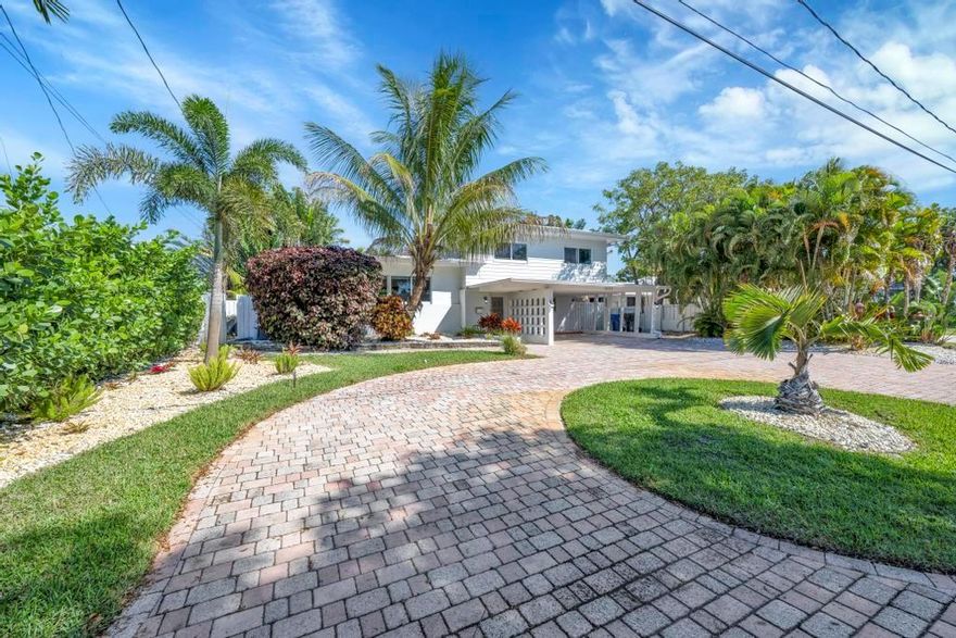 Furnished Coastal Gem with 70 Ft of Water Frontage. Remodeled single family home with newer seawall and hurricane impact windows and doors for peace of mind. The home boasts a three-level floor plan, featuring an upgraded kitchen with wood cabinetry, stainless steel appliances, and a gas stove. With 3 bedrooms and 2.5 baths, the bright and airy interior is designed for comfort and style. Step outside to your private tropical oasis, where tall palms, mango, lime, and banana trees surround a screened-in patio and an oversized saltwater pool, all overlooking the serene Cherry Creek Canal. The curb appeal is undeniable, with lush landscaping and ample parking in the carport and circular driveway. Nestled on a quiet cul-de-sac in a sought-after neighborhood, this home is a rare waterfront find!