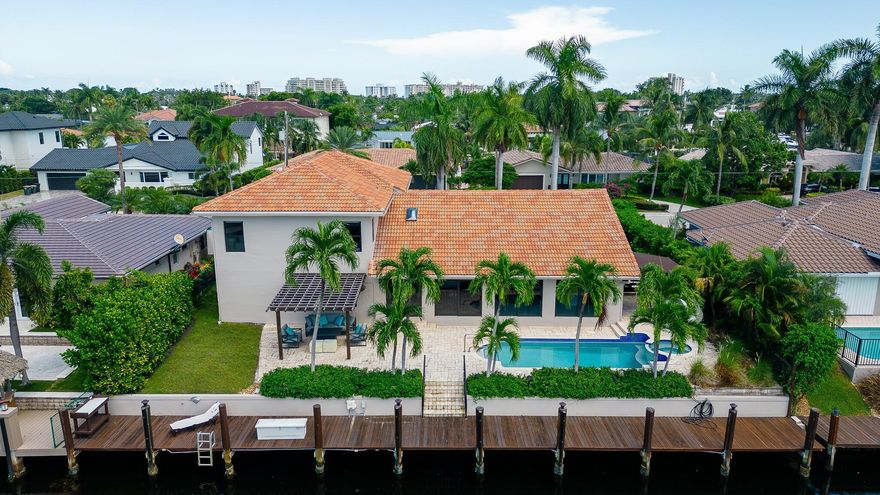 Immerse yourself in waterfront life at this Lighthouse Point gem conveniently located near the LHP yacht club, tennis center, and Hillsboro inlet. This 4 bedroom estate exudes elegance from every corner with new modern floors, light fixtures and finishing touches including 6 custom closets. Enjoy entertaining in this wide open floor plan with soaring ceilings and split bedrooms featuring two primary suites, one ground level. Experience entertaining outdoors with friends and family in your covered (retractable) lounge area, covered gaming area, and pool with waterfall hot tub. Jump on your boat and you’ll access the open ocean in minutes. Nestled away on a quiet street, experience the ultimate privacy combined with access to the highest quality private schools, dining, and entertainment.