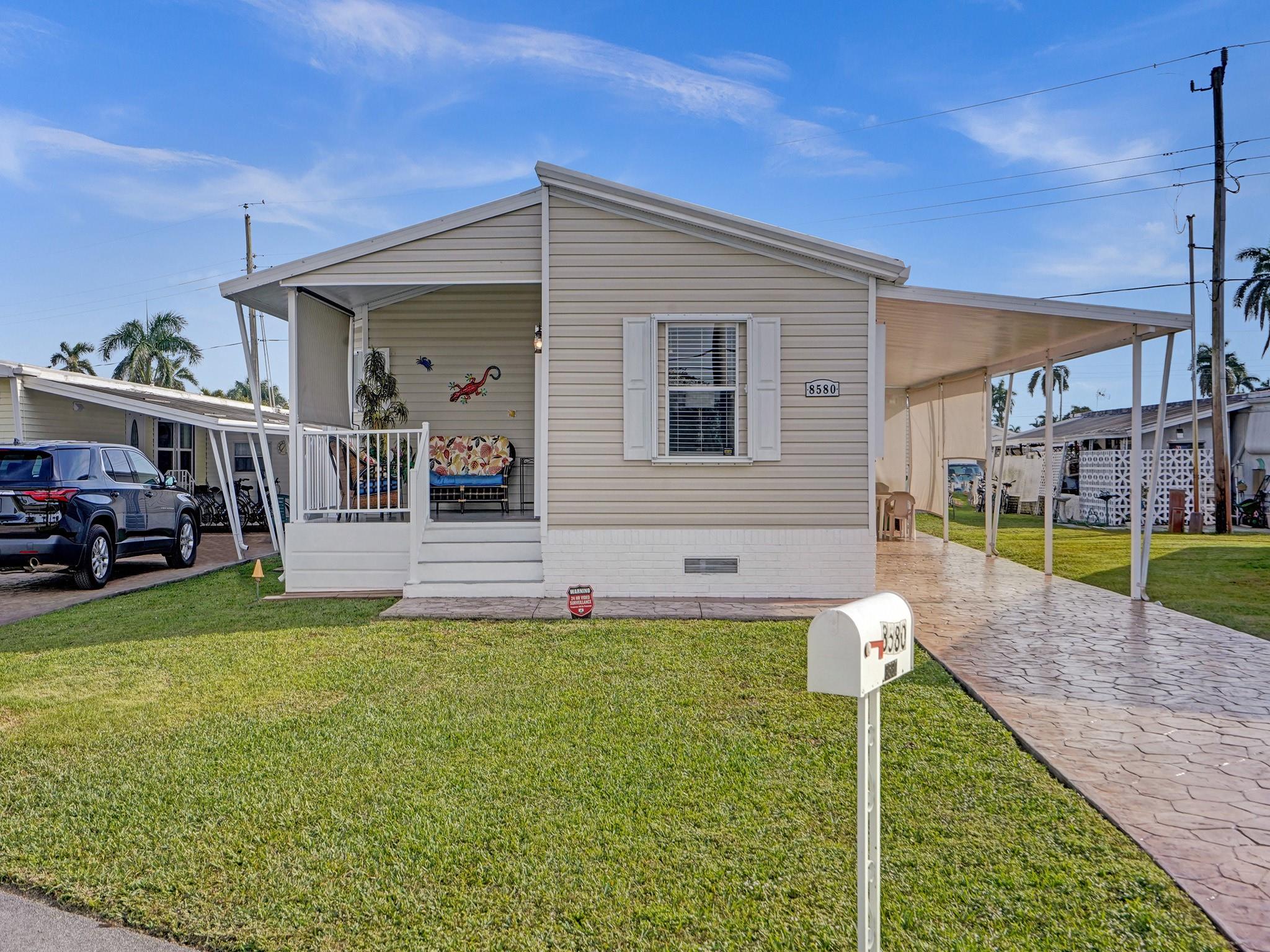 Absolutely beautiful double wide manufactured home in 55+ Park City Estates where YOU OWN THE LAND! Enjoy this lovely 2 bedroom 2 bathroom home with large carport and front porch to enjoy the Florida weather. <any windows bring lots of natural light into this home, and includes other upgrades such as open concept floor plan, spacious bedrooms, stamped concrete driveway, and more. House can be sold all furnished.