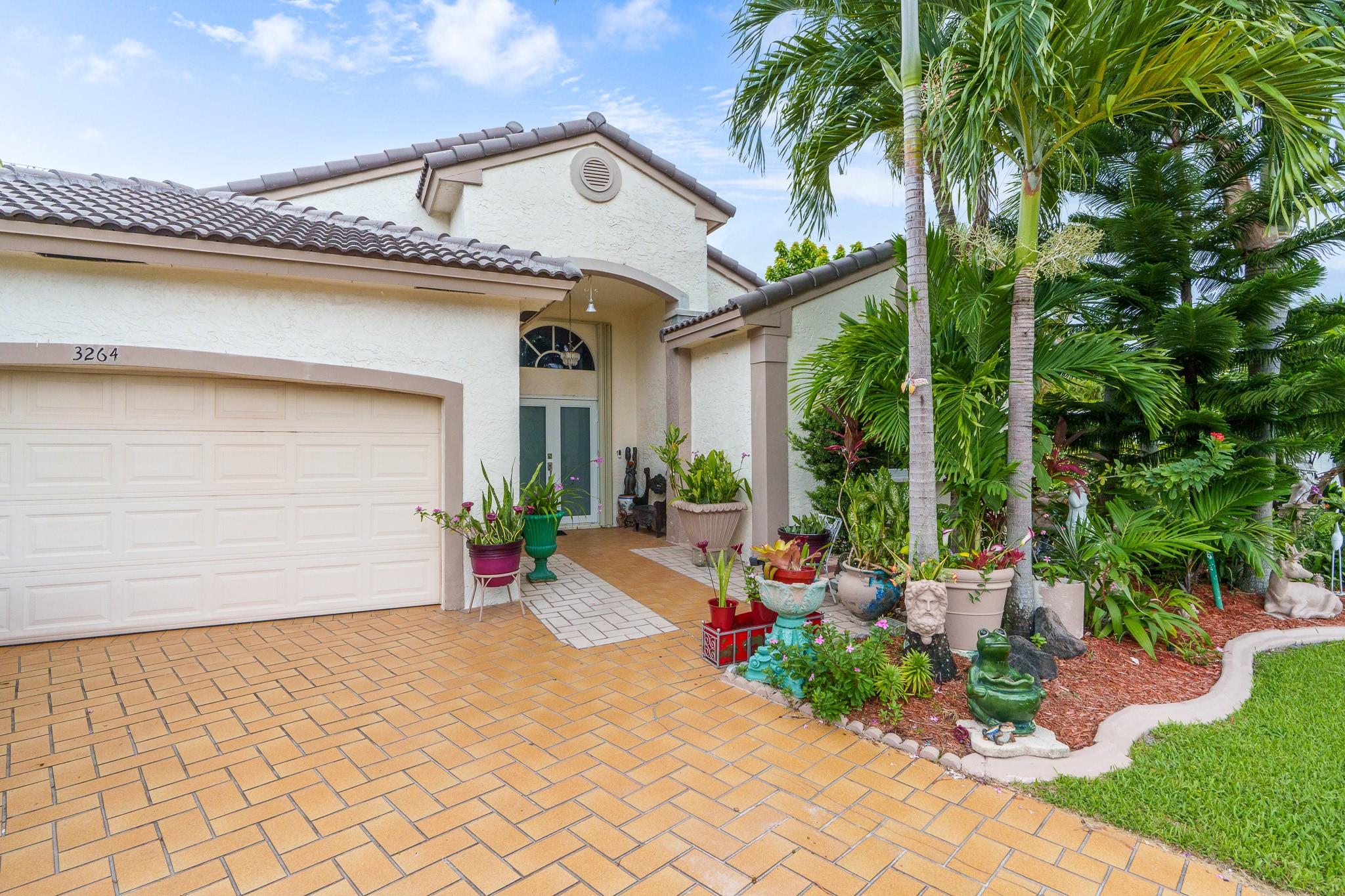 Gated Lake Pointe Estates, welcome home! Your lovely 3 BD/2 BR home with tile floors, vaulted ceilings and solar panels for energy saving. Located on an oversized corner lot with beautiful tropical landscaping, including mature mango and avocado trees. A unique secret pathway leads to a peaceful lake with relaxing views. Lawn stays green year-round with direct lake irrigation. Your home is fully protected by hurricane shutters and impact windows and doors for added Peace of Mind. The community offers great amenities, a clubhouse, heated lakefront pool, tennis courts and a walking trail. Enjoy a welcoming neighborhood with well-maintained grounds and a perfect blend of comfort, nature, and privacy in a desirable Florida location just minutes from shopping, dining and beaches.