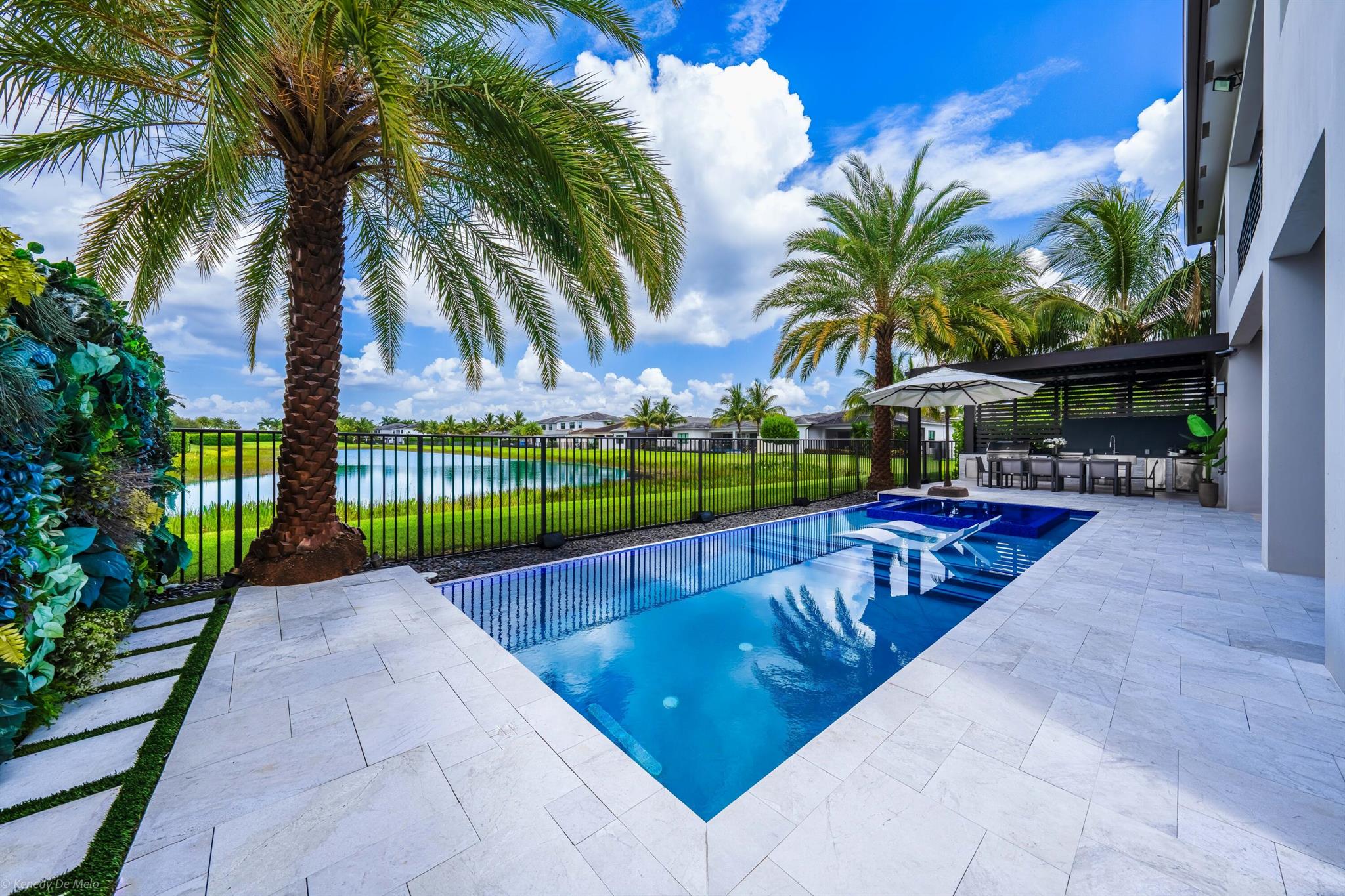 Fully furnished, turn-key estate delivers postcard sunsets over Lotus's widest lake. Every inch is smarter: giant porcelain slabs, natural-oak upstairs, double-height Scatto chandeliers, Toto smart lav. Tesla solar + Powerwalls cut FPL to under $100/mo; zoned AC. Gourmet Wolf/Sub-Zero kitchen, stone & wood accents, 500-bottle glass wine vault, 86-in screens, 2K/4K cams, ultra-short-throw theater. Outside: heated infinity pool/spa w/sun shelf & jets, travertine deck, audio, louvered pergola, Viking summer kitchen, living wall, turf play yard. Extended paver driveway to two 4-car garages + 4 outside spaces --climate-controlled workshop w/New Age cabinets, sink & fridge, plus Powerwall bay w/ceiling racks. EV chargers in both.Auto curtains & crown lights, 13 HD cams. Luxury lease unmatched.