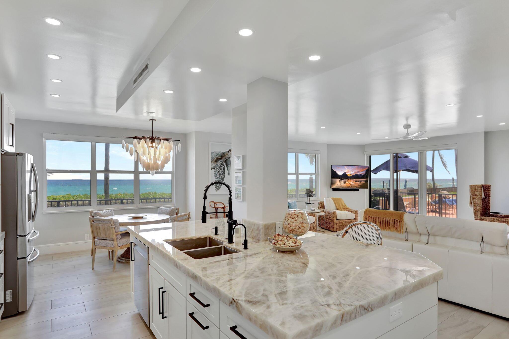 Step into PARADISE, ONE-OF-A-KIND, RARELY AVAILABLE CONDO on the SOUTHEAST CORNER Offering Unparalleled Panoramic Views of the Atlantic Ocean. Breathtaking Sunrises from your Lavish 2/2 Abode. With Electric Access, your Wraparound Patio is a Perfect Haven for Entertaining or Relaxing. Cable, Internet, & Water Included! Luxurious Interior Features include a Chef's Dream Kitchen w/ Custom Wood Cabinetry, Stunning Quartzite Countertops, Large Island, Stainless Steel Appliances, Built-in Microwave, Warming Draw, Instant Hot Water Sink, Wine Cooler & Custom Pantry. This Home Exudes Elegance & Modern Upgrades-Impact Glass, Electric Shades, New Plumbing & Electric, Soundproof Wall in Primary, Porcelain Flooring, Freshly Painted, Reflective Raised Ceiling, Water Filtration, W/D, & Stylish Fixture