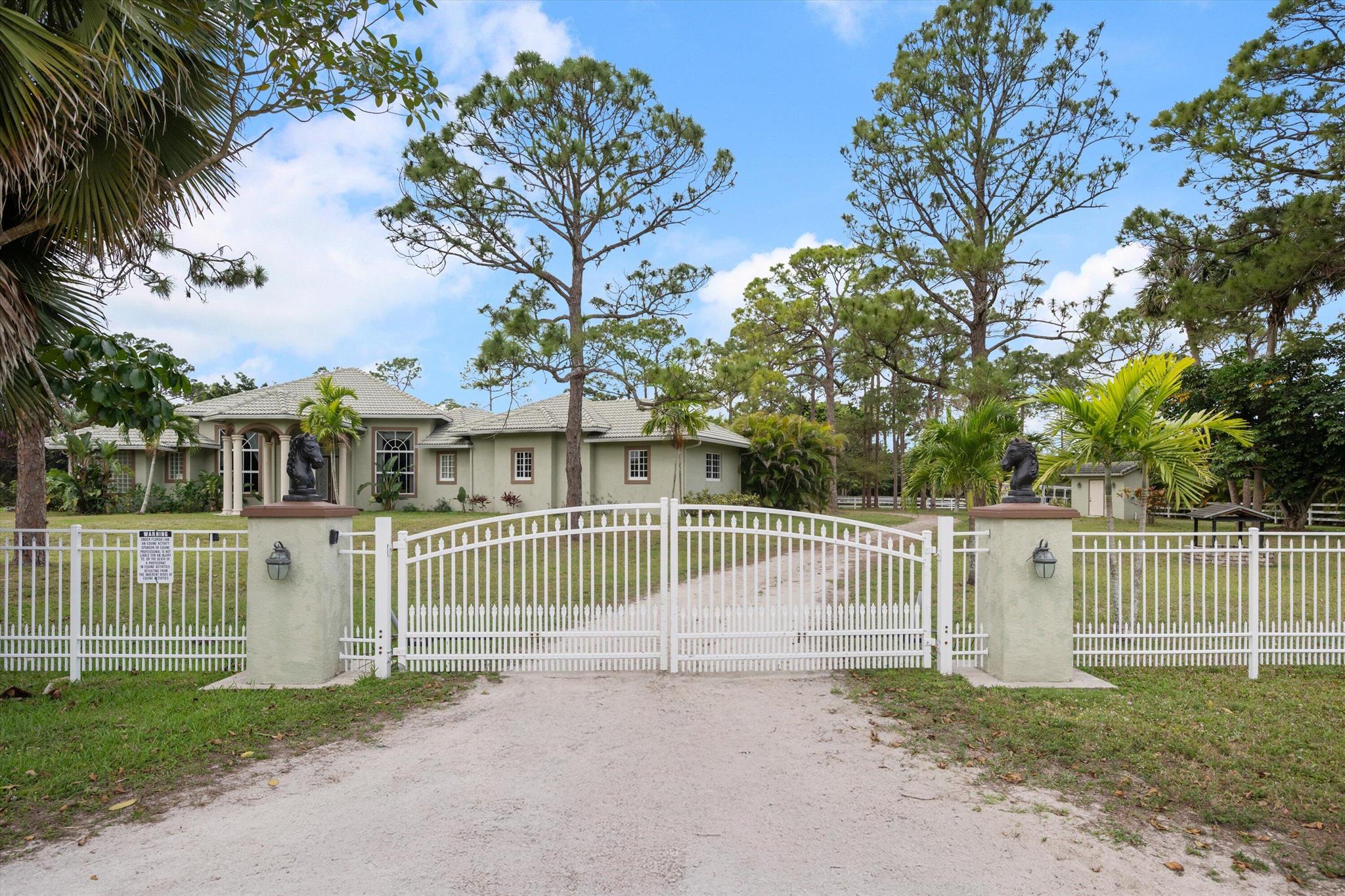 Oversized lot in a great location. This stunning 6.34-acre home features, a 20-stall barn, with a separate feed and tack room, plus an inside wash stall, and 7 large paddocks. A true haven for horse lovers, this high and dry property offers a beautifully designed 5-bedroom, 4-bathroom home with vaulted ceilings, a spacious family room, and a separate pool room. A beautiful kitchen, complete with stainless steel appliances and a double oven, overlooks the inviting pool and hot tub, creating a smooth indoor-outdoor flow.
