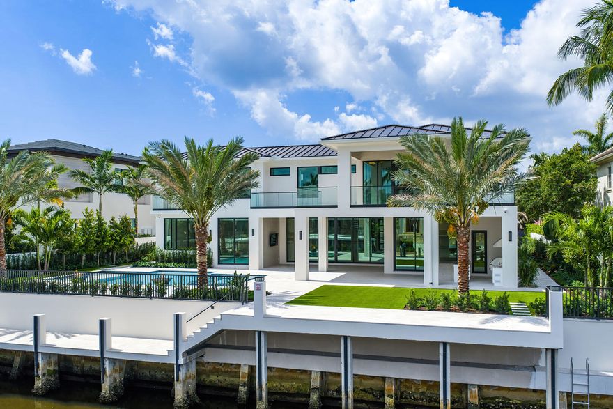 Experience unparalleled luxury in this brand-new waterfront estate in the prestigious Royal Palm Yacht & Country Club. Designed by The Benedict Bullock Group and masterfully built by Hanna Homes, this residence offers over 10,000 square feet of exquisitely crafted living space, seamlessly blending modern sophistication with timeless elegance. A grand entryway leads to expansive living areas, where walls of glass frame breathtaking water views. The gourmet kitchen, complemented by an attached service kitchen, is a chef's dream, outfitted with top-tier appliances and custom finishes. A sophisticated club room with a full bar, a spacious office, and a state-of-the-art gym elevate the home's lifestyle appeal. Seven lavish bedroom suites include an extraordinary primary retreat with dual spa-inspired baths and dressing rooms. Two VIP suites provide luxurious accommodations for guests. Crestron smart home technology, an elevator, and a whole-house generator ensure effortless living. Step outside to a resort-style backyard designed for both relaxation and grand entertaining, featuring a covered loggia with a fully equipped summer kitchen, a striking pool and spa, and a private dock with direct Intracoastal access. This remarkable new construction offers an unrivaled blend of comfort, technology, and waterfront living in one of South Florida's most exclusive enclaves.

The buyer is responsible for documentary stamp taxes on the deed and title insurance.