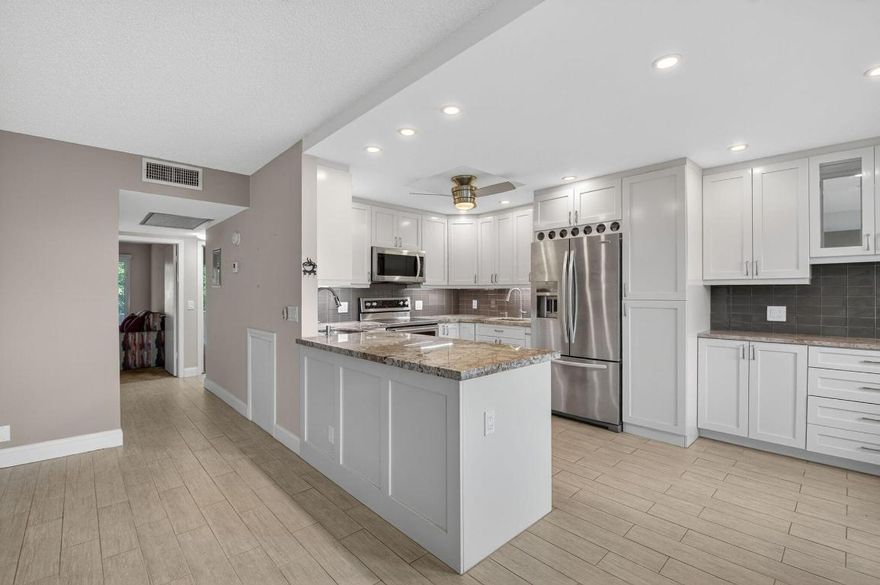 This top-floor, 2/2 condo in desirable Rexford offers quiet, updated living with no upstairs neighbors. Enjoy an open, modern kitchen featuring Quartz countertops and stainless steel appliances. The living area boasts stylish wood-look tile floors. The patio has been transformed into a bonus room with extra storage, thanks to sliding impact windows, providing a tranquil lake view. A newer AC and updated electric panel ensure peace of mind. Close to house of worship and clubhouse. Amenities include internet and WIFI, Century Village is like living in a resort, fitness center, live shows,movies,buses,classes,bingo,card rooms,trips,tennis,pickelball, close to shopping and restaurants,come see and then check out the clubhouse to see it for yourself.