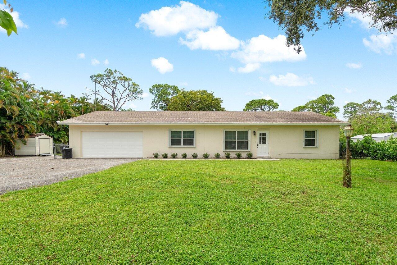 Welcome home! Don't miss this rarely available 3 bedroom, 2 bath, oversized two car garage single family home situated on a private 1/2 acre of land in the desirable Palm Beach Farms neighborhood. This home has a great open layout with a split bedroom floor plan. Beautifully updated with granite countertops in the kitchen, a nice light grey wood tile throughout the entire home and remodeled bathrooms. Off of this kitchen is an oversized laundry room with a full size washer and dryer. Just off of the dining room is a large screened in patio with nice lighting and exposed wood ceilings. No HOA, Zoned for great schools! Lawn Care included in rent.