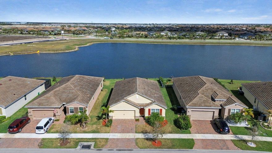 Welcome to this beautifully updated 4-bedroom, 2-bathroom lakefront home in the highly sought-after Preserve at The Estates of Tradition. Freshly painted and featuring brand-new flooring throughout, this move-in-ready residence blends modern style with everyday comfort. Step inside to a spacious open-concept floor plan designed for both relaxed living and easy entertaining. The expansive living and dining areas flow effortlessly into the kitchen, creating a bright and airy space filled with natural light and enhanced by serene lake views. The kitchen offers ample cabinetry and counter space, perfect for gathering with family and friends. The primary suite serves as a private retreat, complete with peaceful water views and a well-appointed en-suite bathroom.  Three additional bedrooms provide plenty of flexibility for guests, a home office, or growing households.  Enjoy the best of Florida living outdoors, where the backyard overlooks the tranquil lake—ideal for morning coffee, evening sunsets, or weekend relaxation. The home also features a functional layout, generous storage, and inviting curb appeal.  Residents of The Preserve at The Estates of Tradition enjoy added value with an HOA that includes cable, high-speed internet, landline phone, lawn care, and access to a community pool—providing convenience and low-maintenance living.