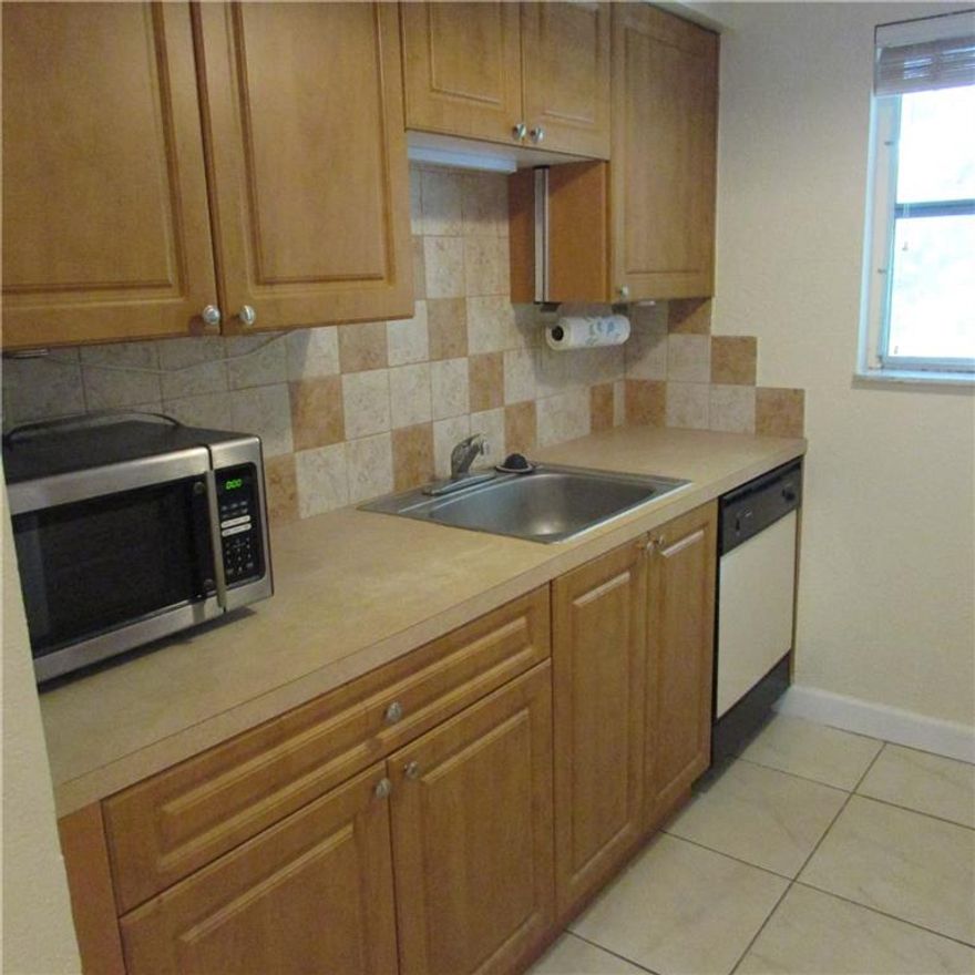 Centrally  located and just a short walk to Wilton Drive. This 2nd floor corner unit comes with all tile floors, extra windows and an in unit washer and dryer.  Add the resort style pool and this is your new home. Sorry no pets. Good credit and clean background required Agents Please submit a full rental application along with your CTL and copy of Drivers license .