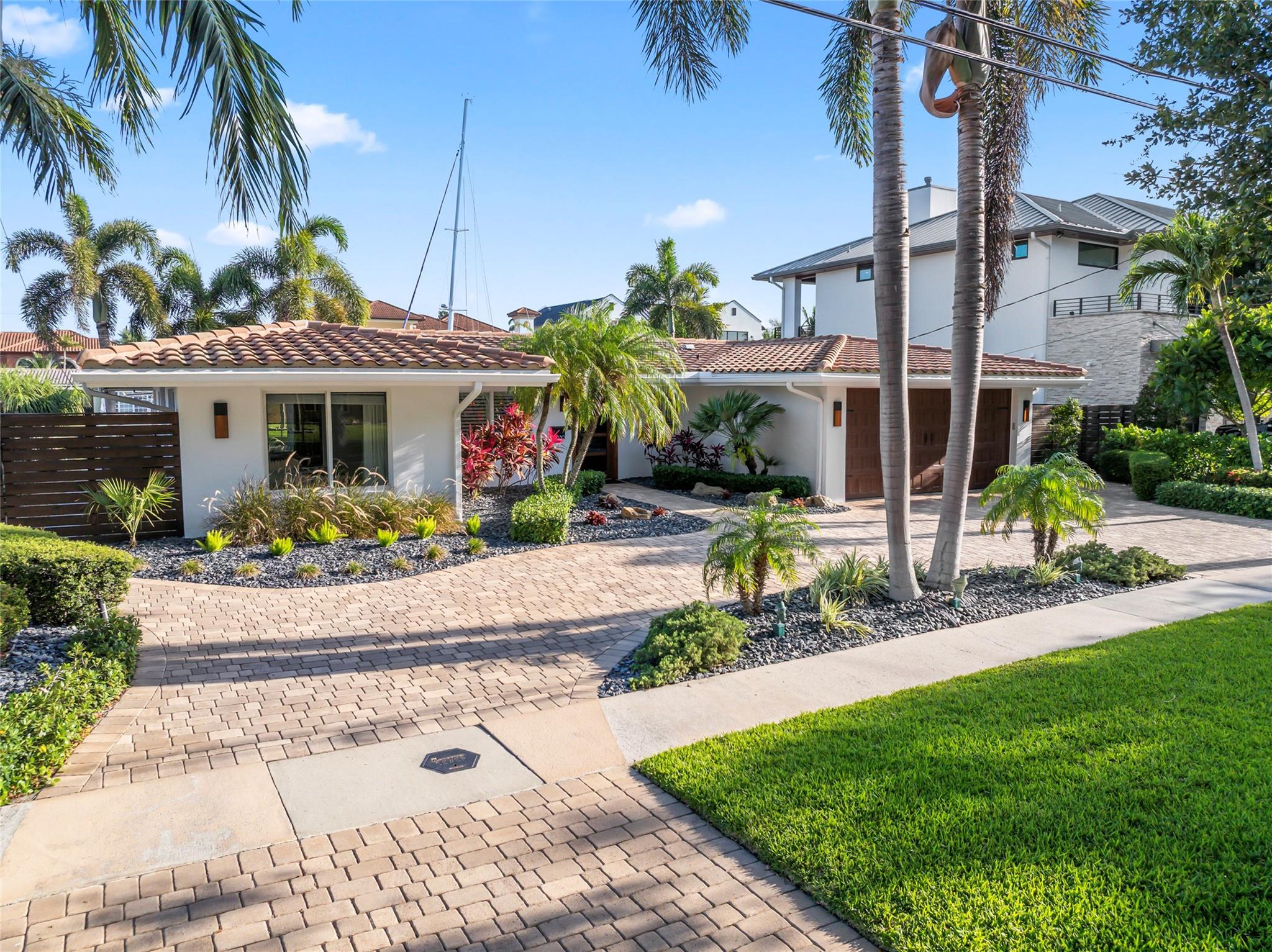 Welcome to your waterfront paradise in sought-after Lighthouse Point! Coral Key Villas is one of South Florida's prime waterfront communities located close to the Hillsboro Inlet, Lighthouse Point Yacht Club, marina, upscale shopping and restaurants. This meticulously remodeled one story 3-bedroom, 3-bath home is a boat lover’s dream with a work-my-boat-dock, new deck, 80 feet of deep-water frontage on an extra-wide ocean-access canal—no fixed bridges for effortless cruising to the Atlantic.
Approach the beautifully paved circular driveway elegantly framed by vibrant landscaping and step inside to discover custom lighting, built-in cabinetry, custom closets, impact-rated windows and doors, and designer window treatments throughout.