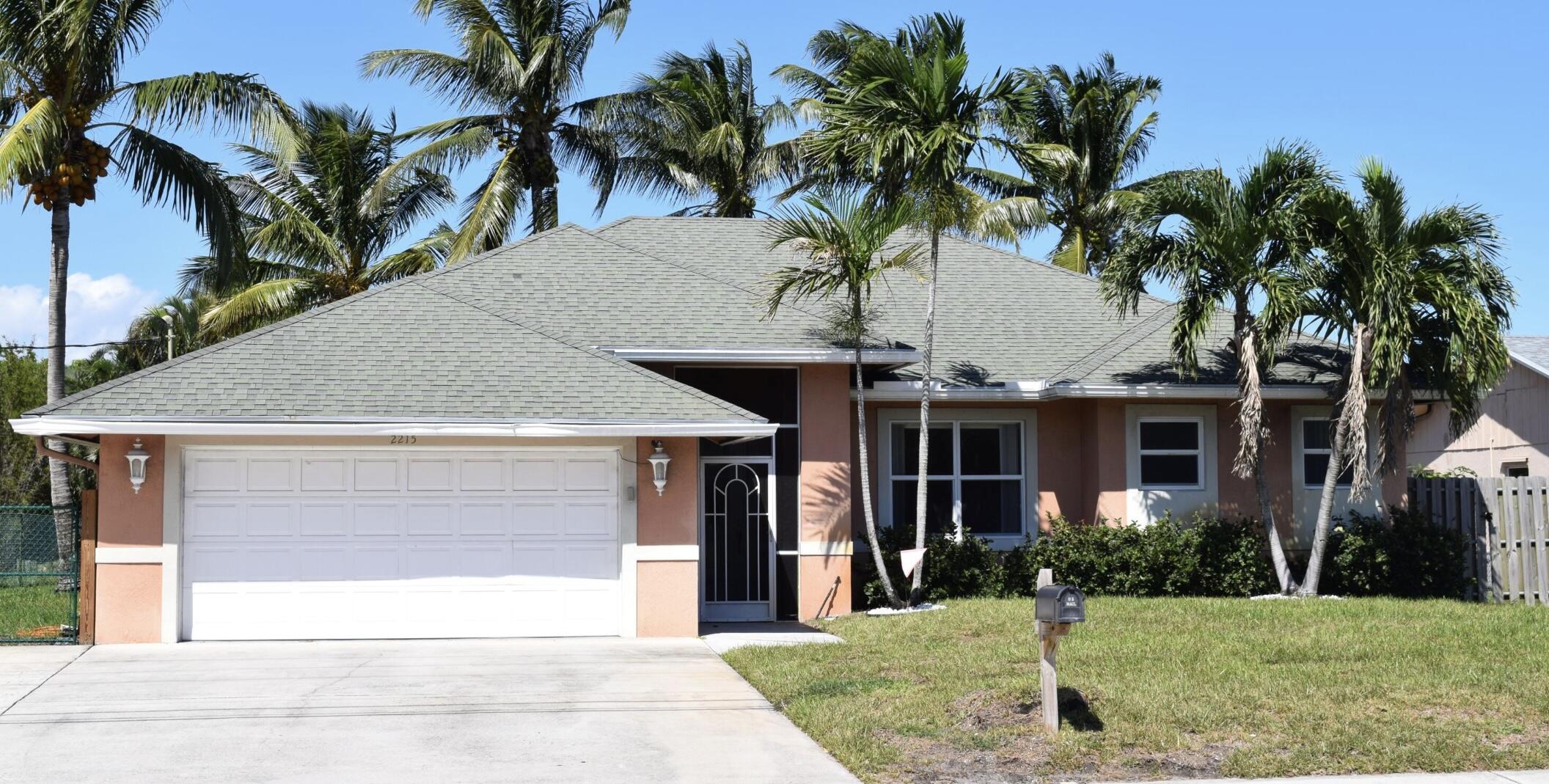 Tropical Waterfront Paradise + Guest House! Excellent opportunity to own this custom built CBS home! Features include: Split bedroom plan, Open Kitchen with Custom Cabinets having pull out drawers and shelves, Granite Countertops, Large Screened Covered Patio, Large 2 Car Garage, Recently Installed Pavers On Side and Backyard, New Bathroom Fixtures, Newer Washer & Dryer, Newly Tiled Family Room, New Irrigation System, Navigable Canal To Stunning Lake Osborne, Boat Lift, Updated Dock Covering, New Garage Door Opener, New A/C Unit in Guest House, Tankless Water Heater for Guest House. Centrally Located, Convenient to Interstate, Shopping, Restaurants, Beaches, Boat Ramps, International Airports. Great Investment For The Water Enthusiasts. Abundant Parking for RV or Boat.Figures Approximate