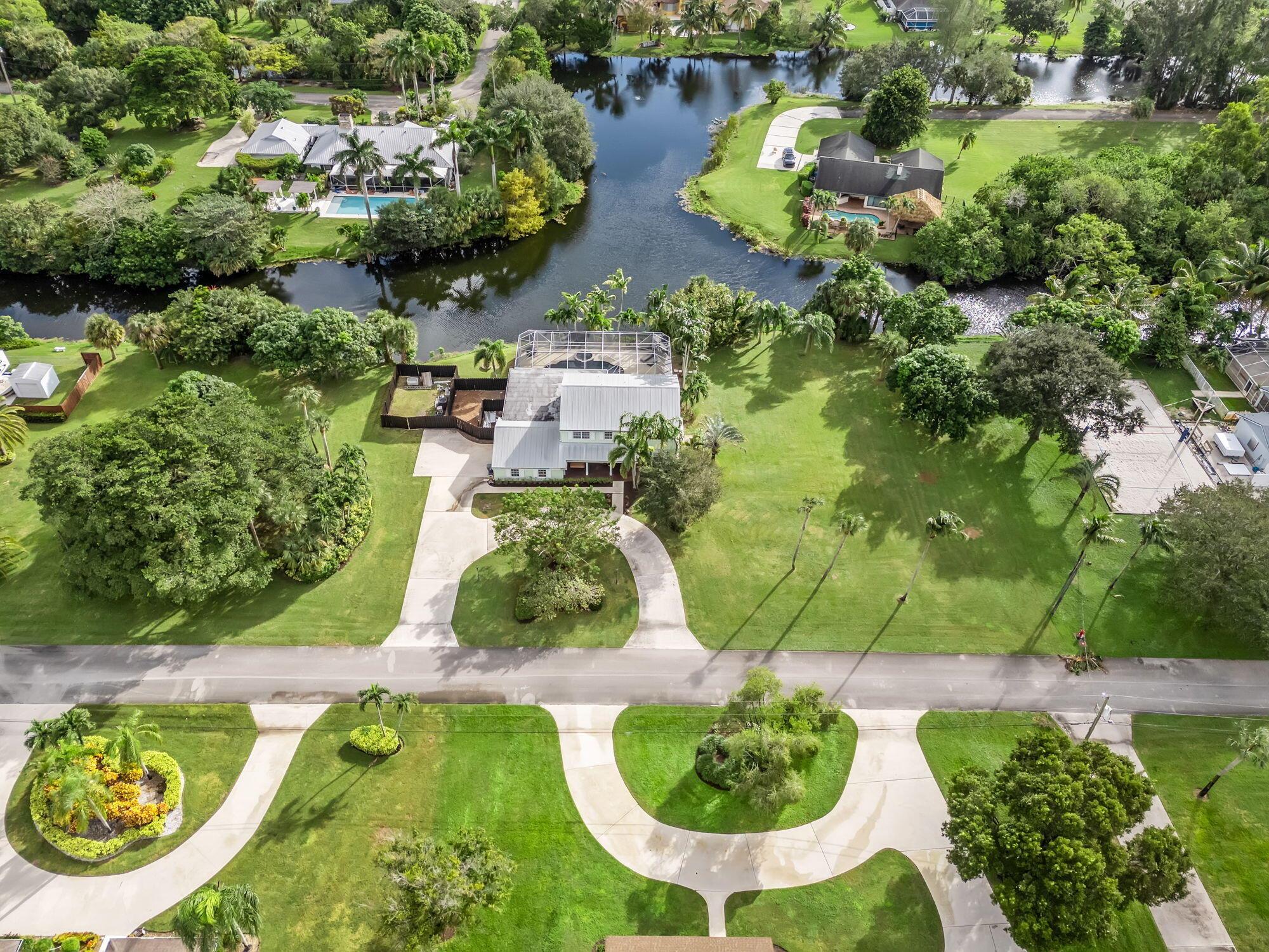 Your Private Oasis Awaits in Whippoorwill Lakes! Tucked away in one of Palm Beach County's best-kept secrets, this beautifully renovated 5-bedroom (+bonus room) 3.5-bath waterfront home sits on 1.48 acres in a quiet gated community. Featuring a brand-new kitchen, open-concept living and oversized screened perfect for entertaining, it's the ideal blend of luxury and comfort. Enjoy the newly updated saltwater pool and spa, luxury laminate throughout entire home, ground floor bedroom plus bonus room and fenced yard. With plenty of room for golf carts a boat or an RV and just minutes from Wellington zoned for the areas top rated public and private schools, beaches, I-95, PBI airport, and top dining and shopping--this is South Florida living at its best!