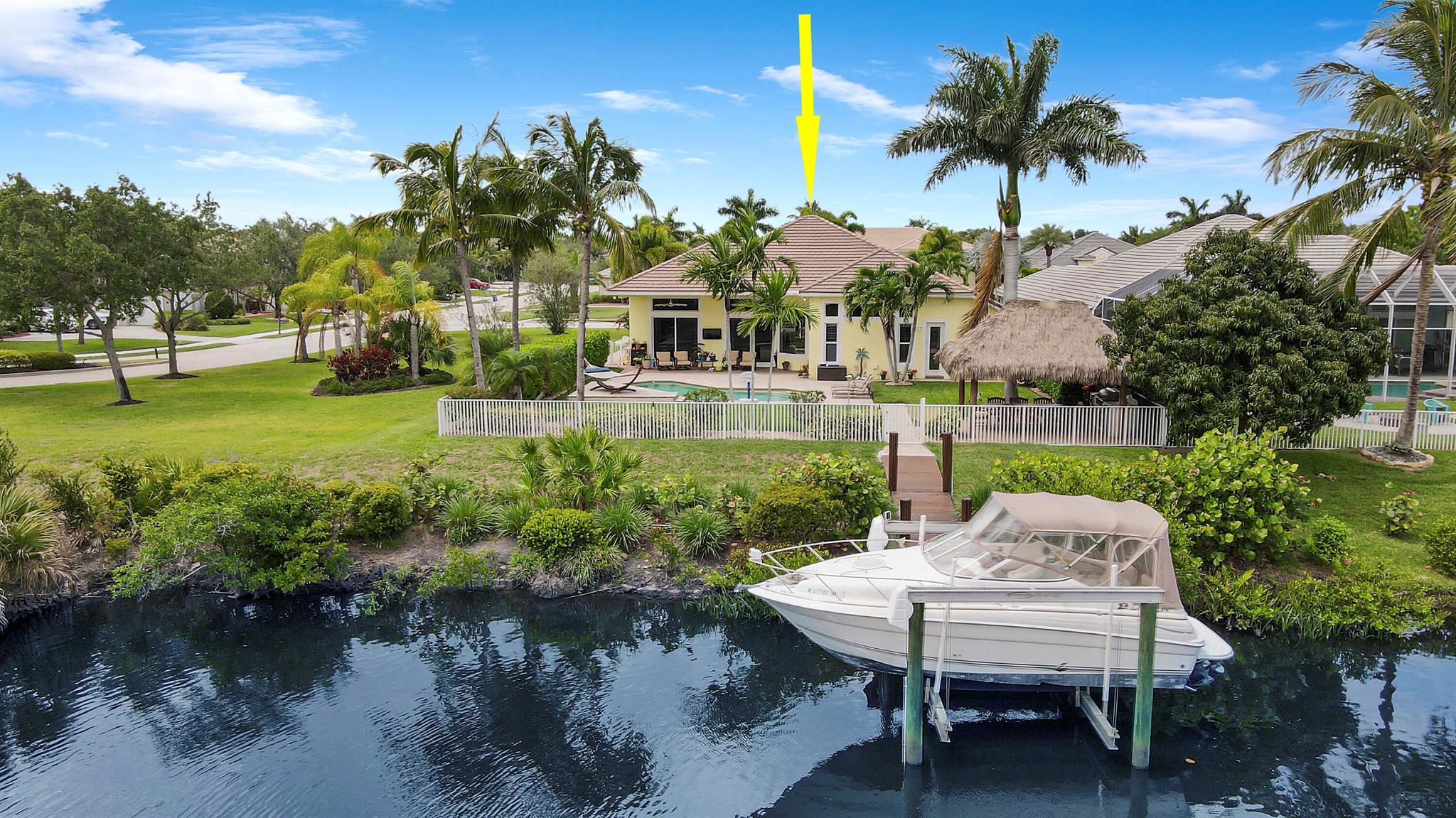 Come see this impressive waterfront pool home located in a gated boating community. This 4 bedroom (plus den/office), 3 bath home is on a deep-water canal with a dock (updated in 2020) and a 13K lift located behind the home with ocean access and no fixed bridges. Great outdoor living with a fenced backyard with an awesome heated saltwater pool and a Tiki Hut with a built-in outdoor style kitchen, lush landscaping and on a corner-lot add to a private setting. The interior of the home is nicely appointed with formal dining and living room and a large combo kitchen and family room. The kitchen comes with stainless steel appliances, 42'' cabinets, granite countertops, double oven, and a center island. Large 3 bay garage allows for good storage. Both A/C units replaced in 2023. Whole house Gen