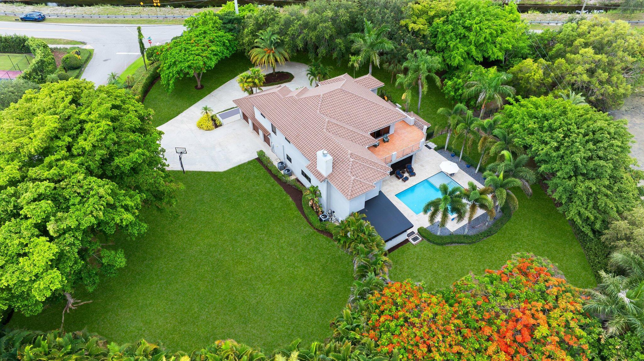 Welcome to 17953 Boniello Road, a remarkable estate situated on over an acre in the highly sought-after community of Boniello Acres in Boca Raton. This spacious 5-bedroom, 4.5-bathroom home offers 6,147 square feet of thoughtfully designed living space, featuring soaring ceilings, an abundance of natural light, and plenty of room for entertaining, relaxing, and everyday living. The primary suite is a private retreat with a spa-like bathroom, walk-in closets, and direct access to a large deck overlooking the backyard. Outside, you'll find an outdoor oasis complete with a resort-style pool and an oversized yard that's perfect for entertaining. Short distance from some of the area's top public and private schools, scenic parks, beautiful beaches, and premier shopping and dining destinations