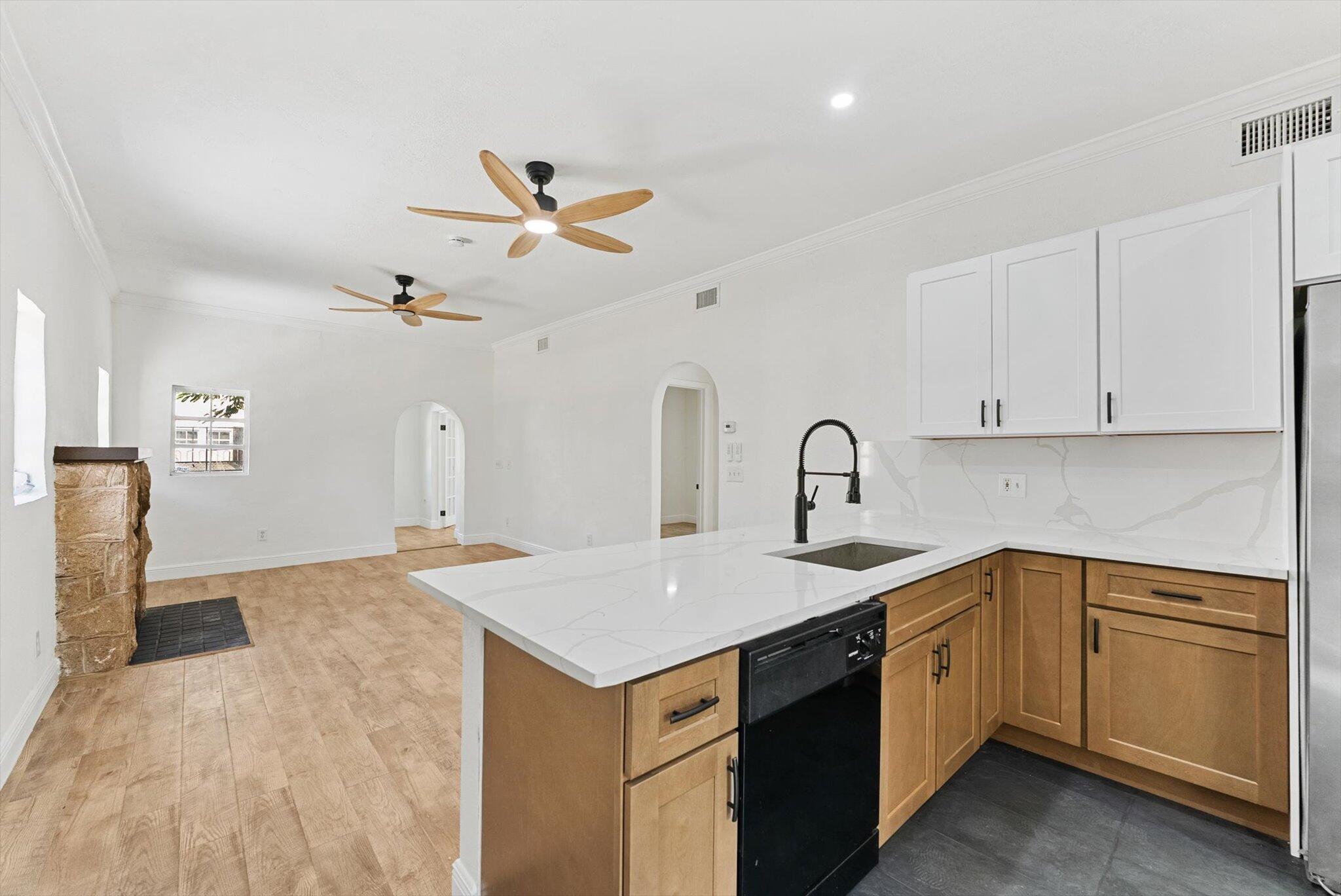 This beautifully renovated Spanish-style home in Lake Worth Beach features three bedrooms and one bathroom. The residence seamlessly blends original charm with modern upgrades, including an arched solid wood front door and a French door leading to the versatile third bedroom or office. The kitchen is equipped with elegant white upper cabinets, wood lower cabinetry, and stunning quartz countertops. A fireplace enhances the living room, while the spacious bedrooms offer ample comfort; the third bedroom is ideal for use as an office. Additional highlights include a large backyard and a detached garage with original barn doors. the Property has Been updated with a new roof and air conditioning system.
