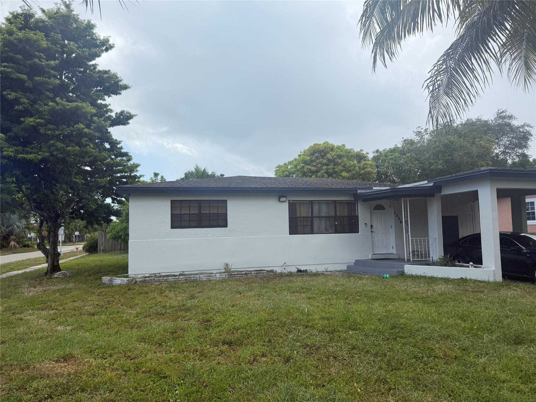 Updated 4-bedroom, 2-bathroom single-family home for rent in Fort Lauderdale. Features include an updated kitchen with stainless steel appliances, renovated bathrooms, spacious living areas, and a corner lot with a massive backyard. The home also offers a dedicated laundry room.
