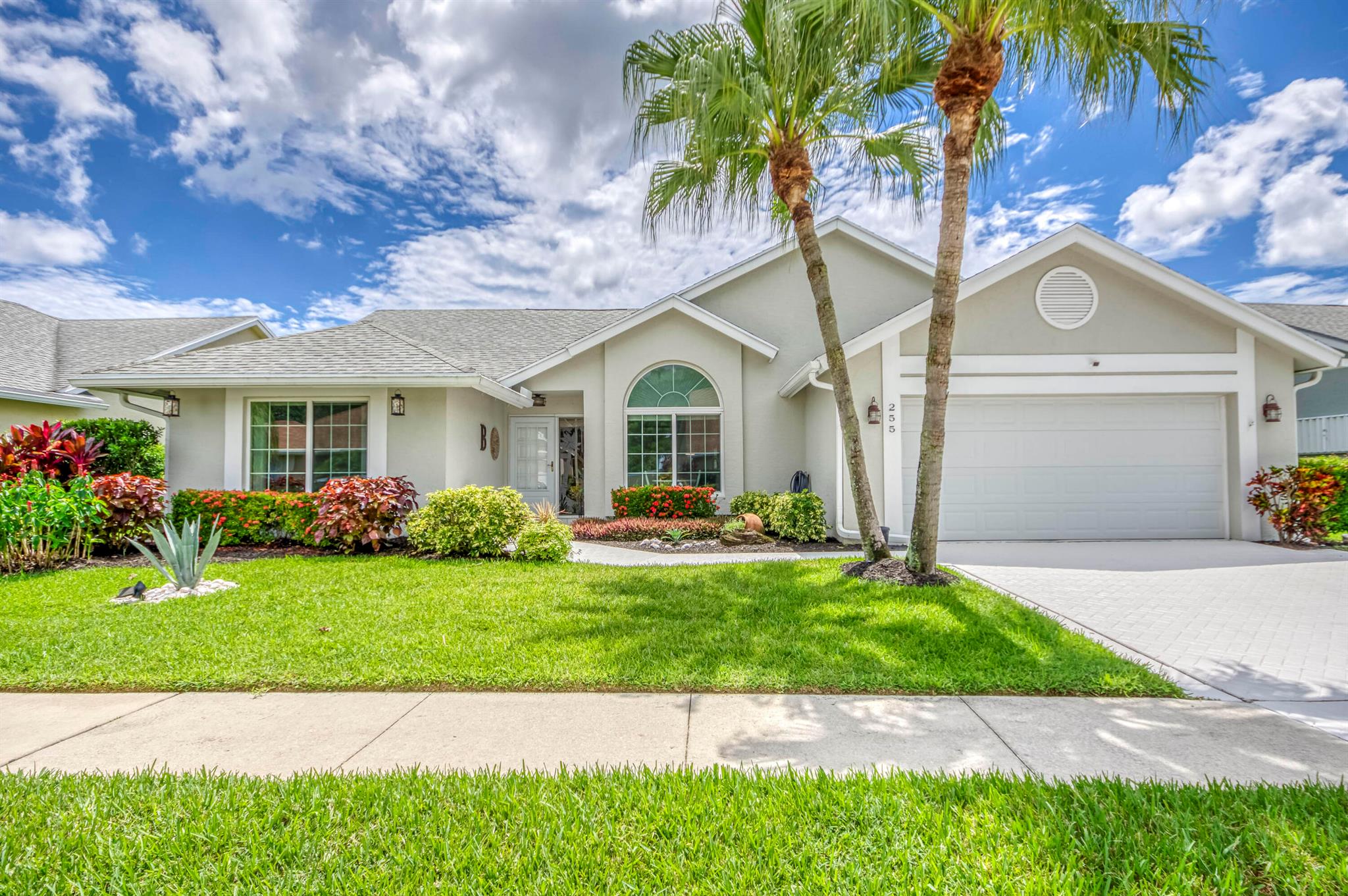 An incredible find in a hidden gem of a community! Welcome to this updated and inviting home with new kitchen and new bathrooms, natural light throughout and soaring vaulted ceilings. The east-facing, screened lanai takes in the morning light and has more than enough space for the jacuzzi tub, fire table, conversation sitting set, or put in an in-ground pool if you choose! More inconspicuous updates are the new electrical box, all new ductwork, and impact windows. This well-managed and manicured community has a low HOA fee, covering your lawn care, cable, internet, and the community pool. 5 minutes to all major conveniences, 20 minutes to PBI Airport, 15 minutes to the beach.