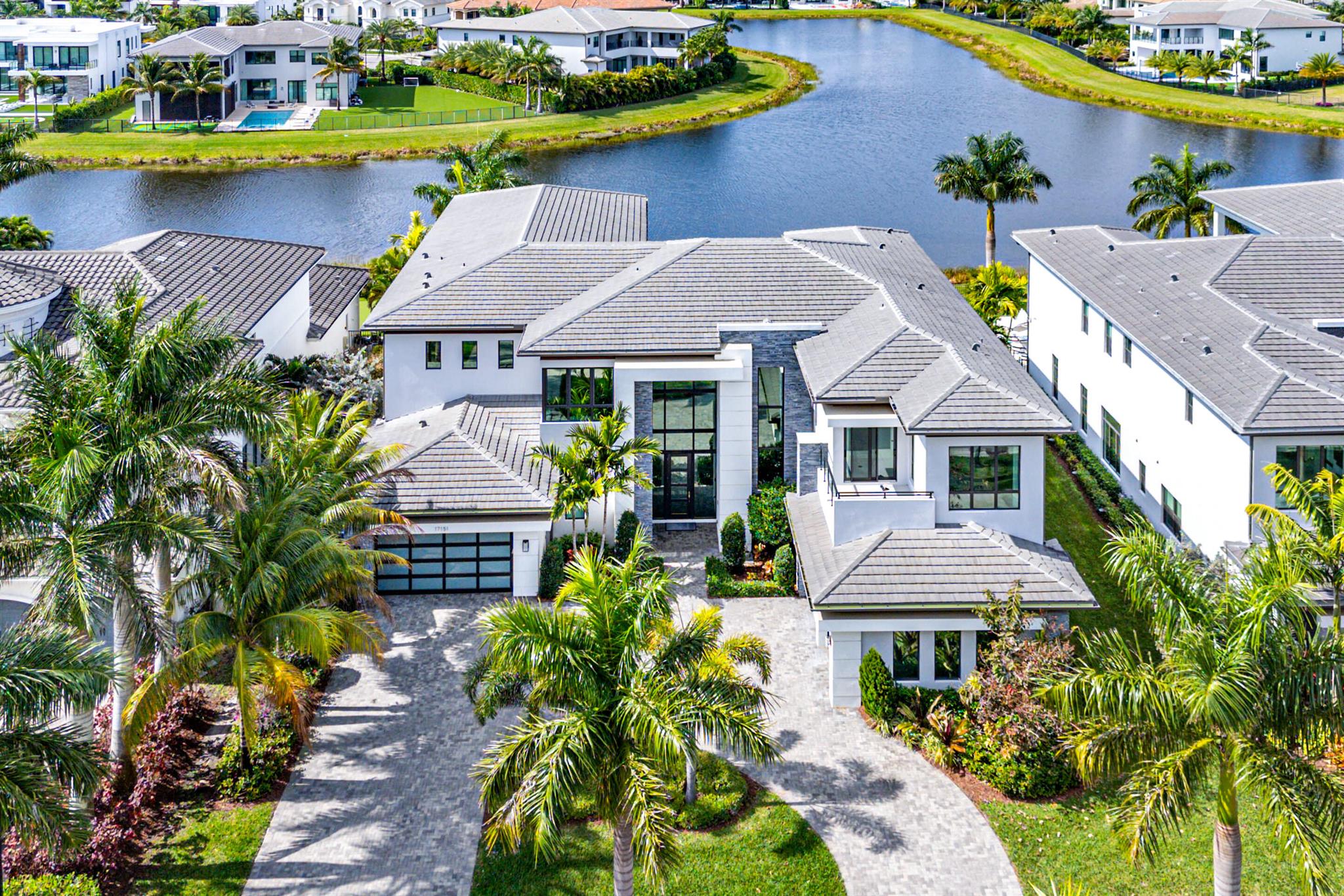 A Masterpiece in the Estate Section of Boca Bridges' Most Coveted LakefrontBoca Bridges -- complete with lavish amenities and elite security -- provides the prestigious backdrop for this meticulously customized Vanderbilt Grande Contemporary. Perfectly positioned on a sprawling, premier long-lake lot, this estate captures breathtaking sunset views and delivers inviting resort-style allure to the luxury residential experience.Spanning over 11,000 total square feet with 8,179 square feet of living space, the exquisitely designed layout offers six ensuite bedrooms, a powder room, a cabana bath, a warm and inviting family room, a loft with private balcony, and a 4-car garage. Inside, striking design elements include a glass-railed staircase, designer millwork, and a sleek gas fireplace