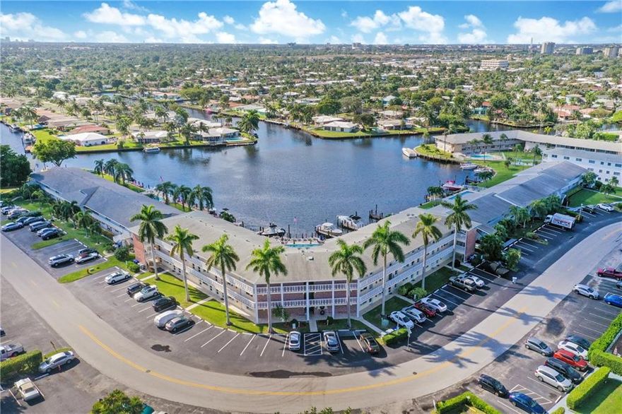 Immaculate one bedroom one bath waterfront condo on serene Pine Lake just 2 miles to the beach. Great place to bring your boat, just one fixed bridge to ocean access. Nothing to be done, move right in, furnishings are negotiable. Relax and enjoy beautiful expansive water views from the screened-in balcony with amazing sunsets, bird watching and visiting manatees. Impact windows and slider, tile and laminate flooring throughout. Laundry room located right next door to unit, extra storage, assigned tandem parking for up to 2 cars. Gorgeous community pool, boat docks as available.