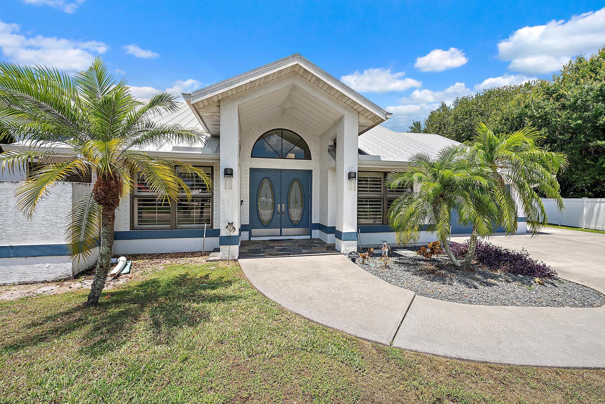 Welcome to this beautifully upgraded pool home nestled on a spacious half-acre lot at the end of a quiet cul-de-sac in one of Port St. Lucie's most desirable neighborhoods. This thoughtfully designed 3-bedroom, 2.5-bath residence combines comfort, style, and functionality, featuring a host of top-to-bottom enhancements that elevate everyday living.Step into a light-filled great room where new wood floors, recessed lighting, and elegant wooden paddle fans create a warm and inviting ambiance. The home is equipped with three AC systems and a new EcoBee WiFi thermostat, ensuring energy-efficient climate control throughout the year. Plantation shutters, installed in 2020, add timeless charm while offering excellent light control and privacy.