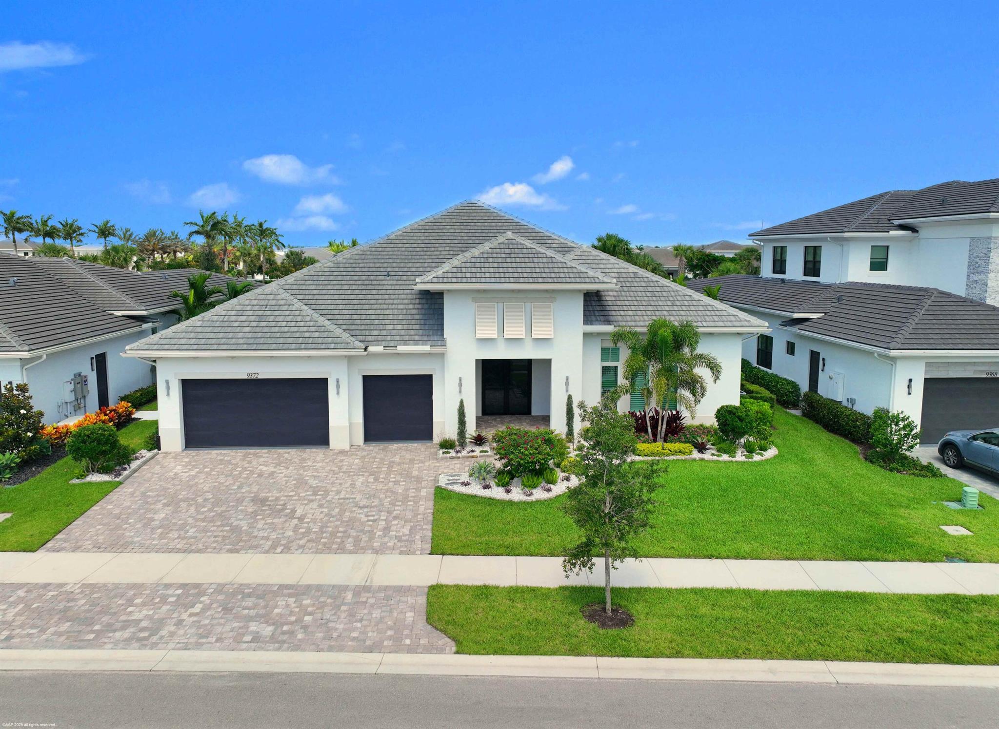 Experience refined Florida living in this exquisite 5-bedroom, 4.5-bathroom estate, perfectly positioned in one of Palm Beach Gardens' newest gated communities- Coral Isles at Avenir. Designed for both elegance and comfort, this single-story home offers exceptional craftsmanship, a thoughtful open-concept layout, and an outdoor oasis that rivals any resort. From the moment you arrive, the home's striking curb appeal sets the tone. A paver driveway leads to the spacious 3-car garage, while lush tropical landscaping, enhanced by professional landscape lighting, welcomes you to the front entry. Inside, soaring ceilings, expansive windows, and designer finishes create a light-filled, inviting atmosphere.