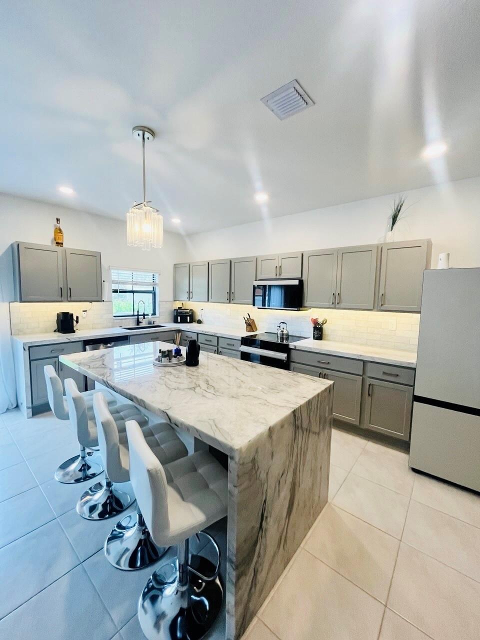 Experience the pinnacle of sophistication in this newly built (2024) 3-bedroom, 2.5-bath townhome in the heart of Pompano Beach. Designed with elegance in mind, it boasts soaring ceilings, an open floor plan, and designer finishes throughout. The gourmet kitchen features rare quartzite countertops, a statement marble backsplash, premium stainless steel appliances, and sleek cabinetry. A striking wood slat accent wall in the living area creates a contemporary focal point, adding warmth and style to the space. Upgrades include a tankless water heater, an energy-efficient Carrier AC, and a private one-car garage with additional driveway space. Ideally located minutes from pristine beaches, upscale shopping, and fine dining, this townhome offers the perfect balance of lifestyle and luxury.