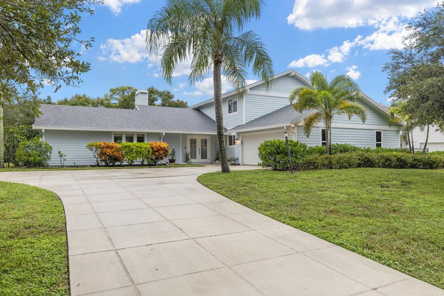 Rare opportunity to own just over half an acre (.56) home in the highly sought-after, Whispering Trails of Jupiter! This pool home combines strength, style, and low-maintenance living with reinforced concrete walls, 2021 roof, full impact windows and doors, impact garage door, and hardie board siding offering durability and timeless curb appeal. Step through stunning French doors with artistic impact glass into an upgraded home with stunning picture windows ready for your vision. The upgraded chef's dream kitchen, boasts Miele Steam and Conventional Ovens ($30,000+ value), Wolf Oven, great kitchen island with granite and butcher block countertops offering plenty of storage, herringbone backsplash, farm sink, and custom soft-close cabinetry. A cozy breakfast nook and family room