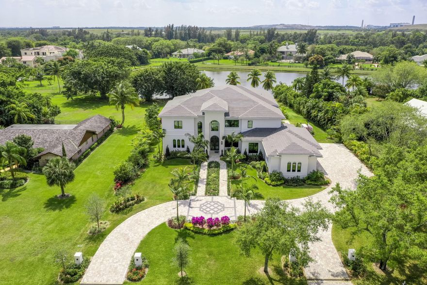 Custom lake front estate redefining luxury in the private gated community of Steeplechase. This 6 bed, 9 bath trophy home spans over 8,000 square feet with an impressive array of exquisite finishes and features. The incredible attention to detail can be felt immediately upon entering the foyer with massive 25' ceilings, elegant wall features, and grand staircase. The main living area flows seamlessly into the other portions of the home, while massive floor to ceiling windows provide natural light and beautiful lake views throughout. The gourmet kitchen is a chef's paradise, complete with Sub Zero & Wolf appliances, double center islands with waterfall quartzite, custom maple cabinetry, and walk-in pantry. Imported Italian porcelain on the main level and White Oak floors upstairs bring a distinct level of sophistication and refinement to the home. The pool deck features 2,000 square feet of sandblasted marble, fully equipped summer kitchen, outdoor shower & cabana bath, and an olympic size infinity pool. A truly elegant modern architectural masterpiece, this newly built estate boasts over an acre of direct waterfront on one of the most prime lots in the community.