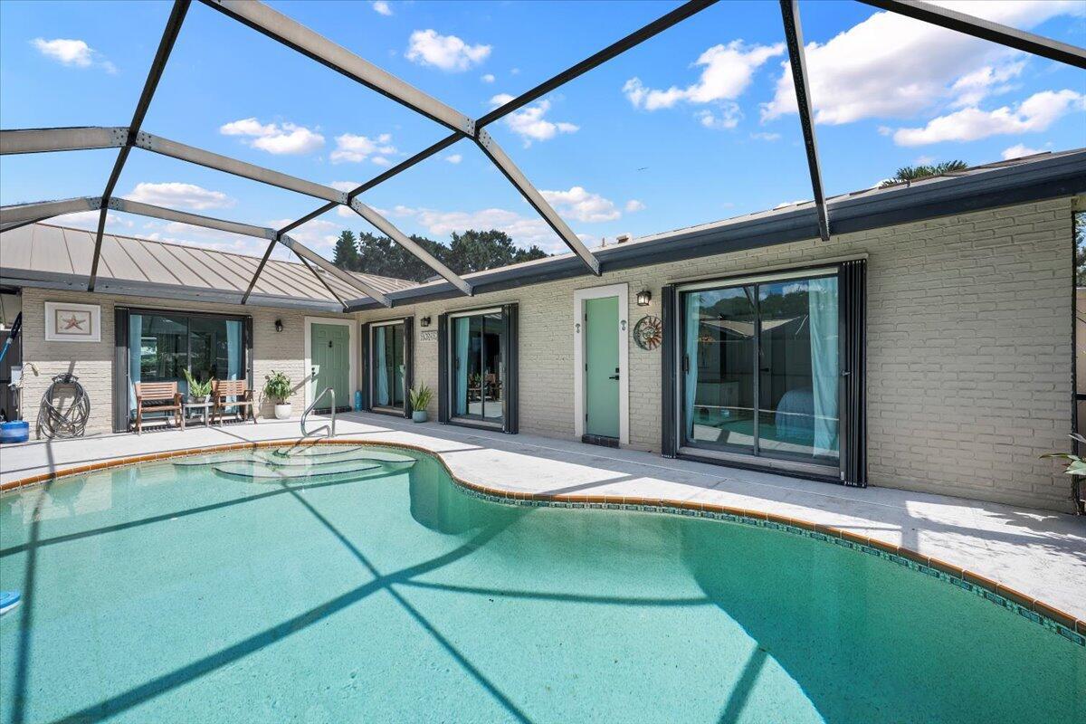 Experience Florida living at its finest in this stunning single-story corner unit townhome in the highly desirable community of Westwood Gardens. Enjoy gorgeous lake views, breathtaking sunsets, and the comfort of private pool living with a screened-in patio-perfect for relaxing and entertaining all year round. This 3-bedroom, 2-bath home offers a spacious split floor plan with vaulted ceilings and all-new flooring throughout, creating an open, airy feel. Each bedroom features sliding glass doors that open directly to the pool area, seamlessly blending indoor and outdoor living. The updated kitchen includes modern finishes and an under sink reverse osmosis system, complemented by a full-house water filtration system for added convenience. Some updates include a metal roof,