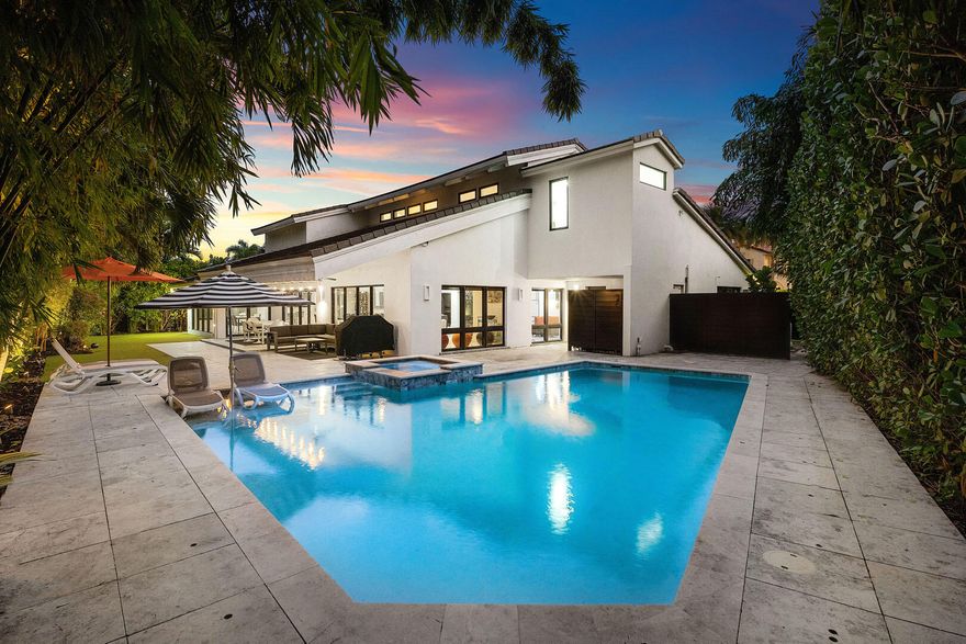 A refreshed two-story mid-century modern residence, this home is defined by dramatic vaulted wood ceilings, warm architectural character, and an effortless sense of style across just over 4,000 square feet of living space. Designed for both everyday comfort and elevated entertaining, the layout offers four spacious bedrooms and four-and-a-half beautifully appointed baths. At the heart of the home, a gourmet eat-in kitchen features a striking center island and premium appliances, creating a natural gathering place for family and guests alike. A glass-enclosed study overlooks the shimmering pool, offering a serene workspace framed by views of the backyard oasis. Step outside to a private retreat where a custom heated pool and spa invite year-round enjoyment, complemented by an outdoor shower and low-maintenance turf landscaping. The covered patio is perfectly arranged for al fresco dining and relaxed lounge seating, delivering the ideal indoor-outdoor lifestyle.
The primary suite is a true sanctuary, complete with a spa-inspired bath and dual walk-in closets. Additional highlights include natural gas service, a generator, and impact glass throughoutproviding comfort, security, and peace of mind in a residence that feels both timeless and perfectly updated.