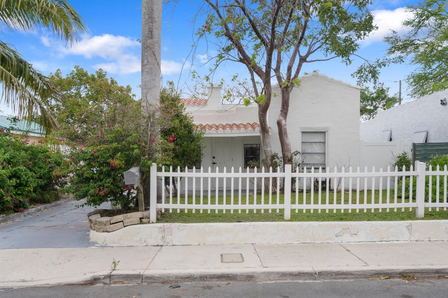 Stunning Spanish Mission-style 3-bedroom, 2-bath home blending timeless charm with modern upgrades! Featuring a brand new roof (2025), desirable split floorplan, two beautifully renovated bathrooms, and central A/C. Character details include exposed wood beams and built ins in the primary suite, decorative fireplace, and a bright front sunroom perfect for relaxing. Enjoy a spacious laundry and utility room with extra storage. The exterior offers a private fenced yard, carport, and long driveway with ample parking for multiple vehicles, boats, or guests. Alexa-controlled custom lighting, hard wired security system and smart doggie door adds a modern touch throughout. No HOA! Ideally located just minutes to CityPlace, downtown West Palm Beach, top dining, shopping, and the beach.