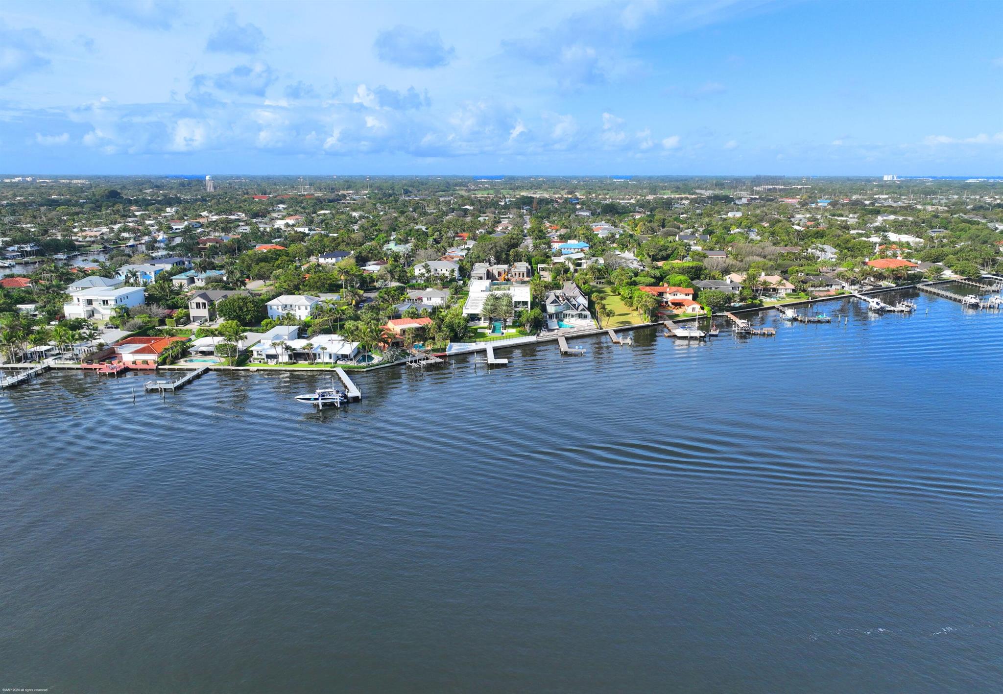 From the moment you enter the gates of this massive direct Intracoastal waterfront estate, you will experience first hand the hundreds of hours of creative design by famed and respected architect George Brewer. His vision coupled with the direction and inspiration from the owners' decades of world travels have created this stunning modern masterpiece that was completed in 2021.Water is the main focus as you experience it throughout this nearly one acre property. From the front entrance and its cascading fountains, to the walls of glass that frame the entire eastern elevation of the home showcasing the massive resort style pool and turfed courtyard including a unique acrylic heated spa actually sitting in the water, to the expansive Intracoastal waterfront that has one of the