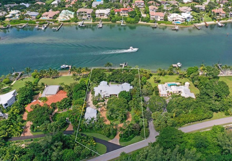 A Spectacular Island Style home, on the Intracoastal Waterway, creates a personal Jupiter Island paradise! Situated on a beautifully landscaped 1.32 acres, the property is complete with boat dock and lift, being just minutes from the Inlet for access to the ocean and conveniently located on the south end of the island. DEEDED BEACH ACCESS across the street to take in the deep blues of the Atlantic Ocean.
The main house is meticulously maintained and includes a delightful pool area, perfect to swim, sunbathe and entertain guests.  Also, a charming 2 bedroom, 2 bath guest house with full kitchen, dining area and spacious living room allows for privacy for all!